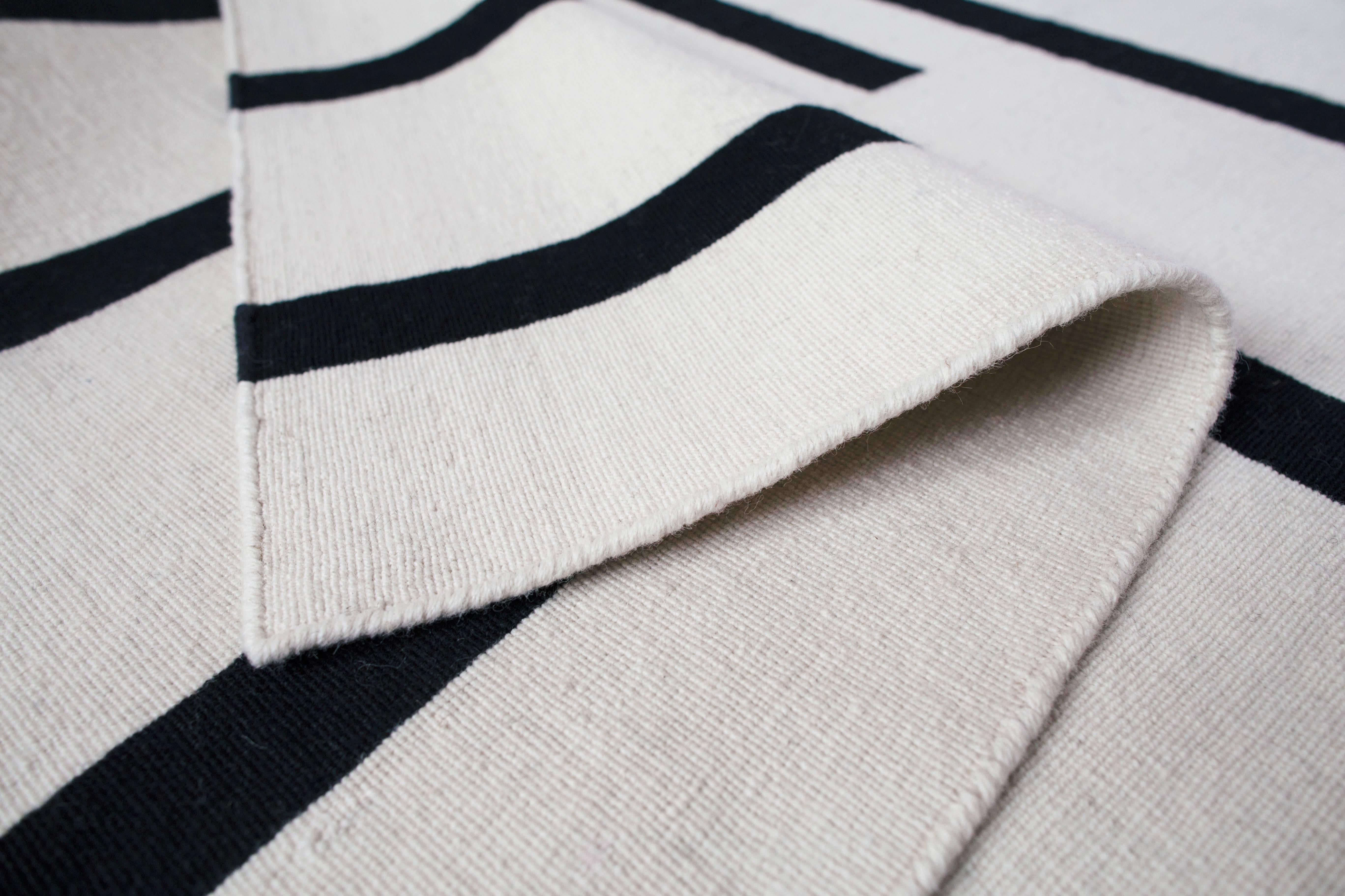 Tiger Cream/Black is a modern Dhurrie/Kilim rug in Scandinavian design.
Please note that lead times vary by size and range from 6 days - 16 weeks.

Our Swedish tiger has bold black stripes on muted colors that will add both character and warmth to