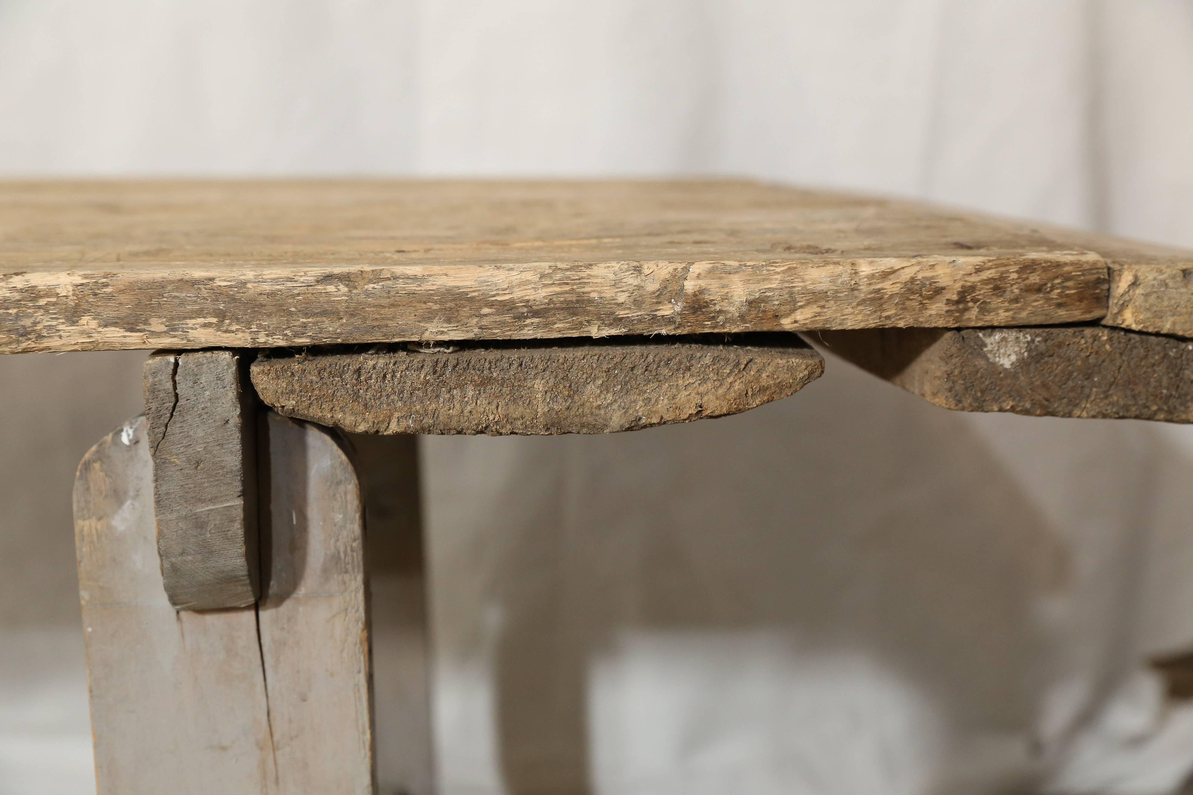 Rustic wood table with sawhorse legs. The wood varies in color and texture. Found in Provence.