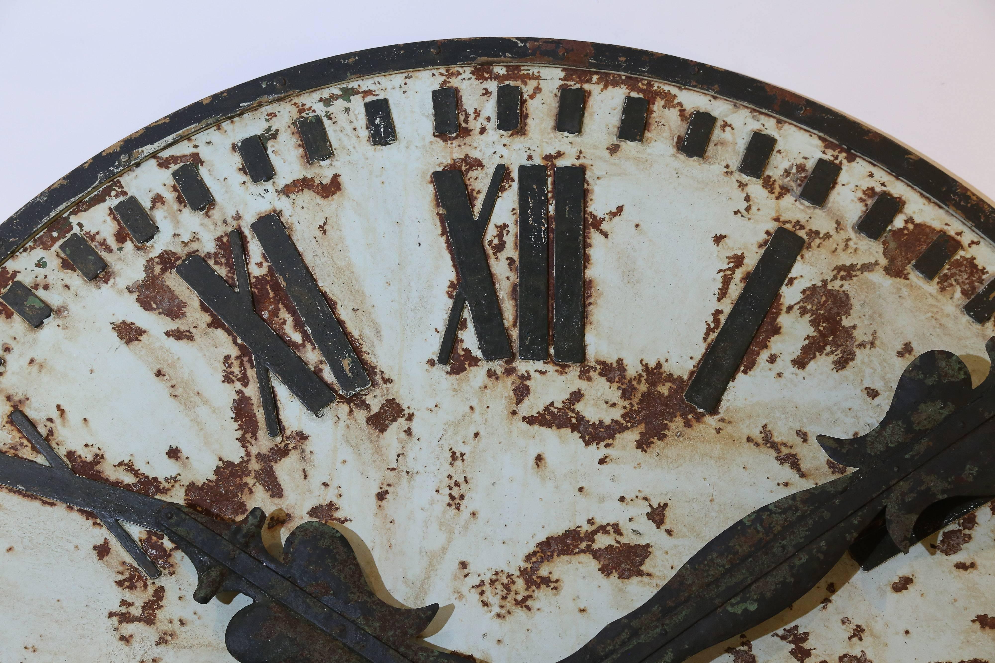 A marvelous decorative clock face from France. It's rusted metal surface retains traces of the original pale green paint.