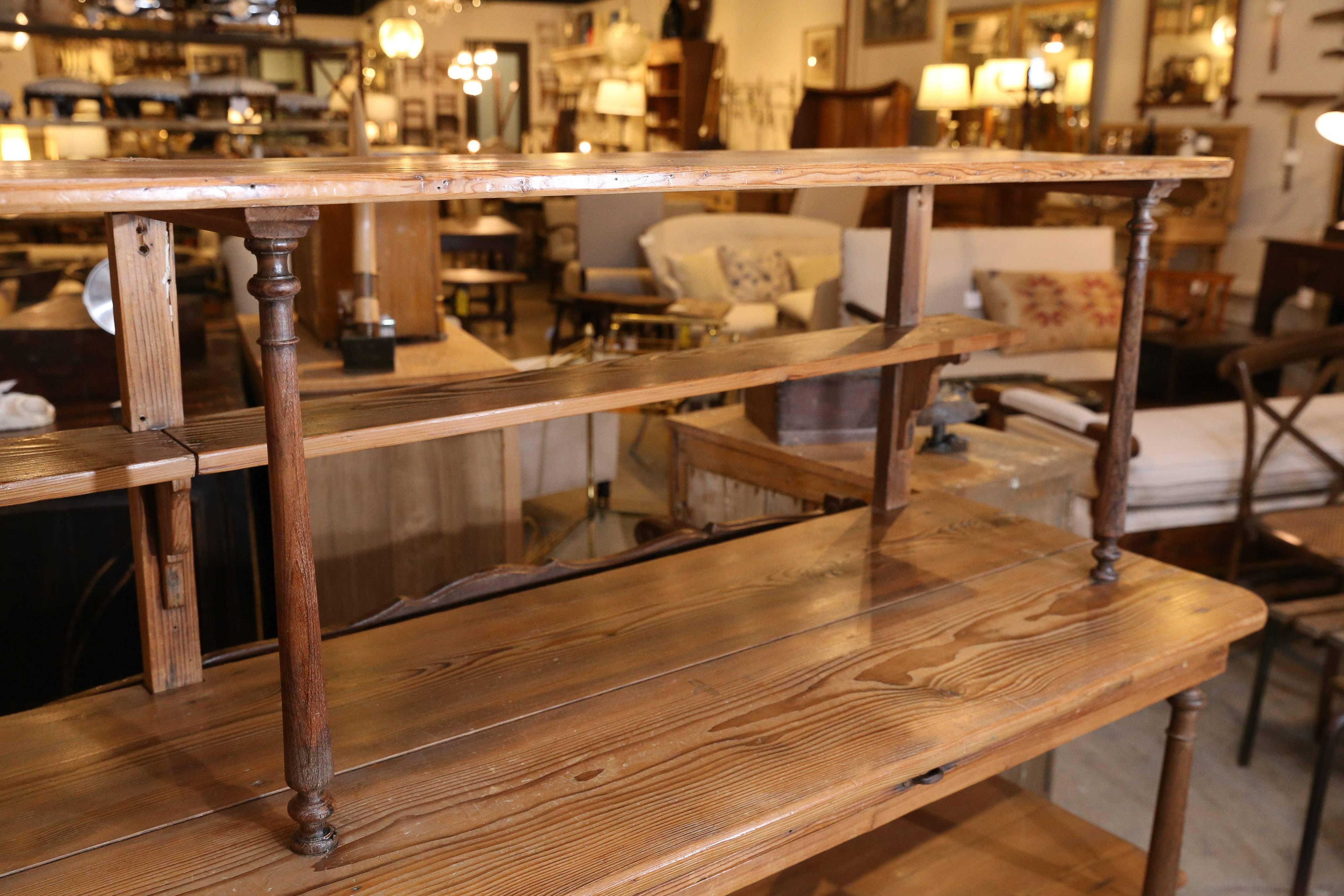 Dating back to the 1800s, this outstanding patisserie shelf from France is an exceptional find. Solid and sturdy with four full shelves, one small half-shelf, and an additional 35 inch pull-out. Void of decoration with the exception of the turned