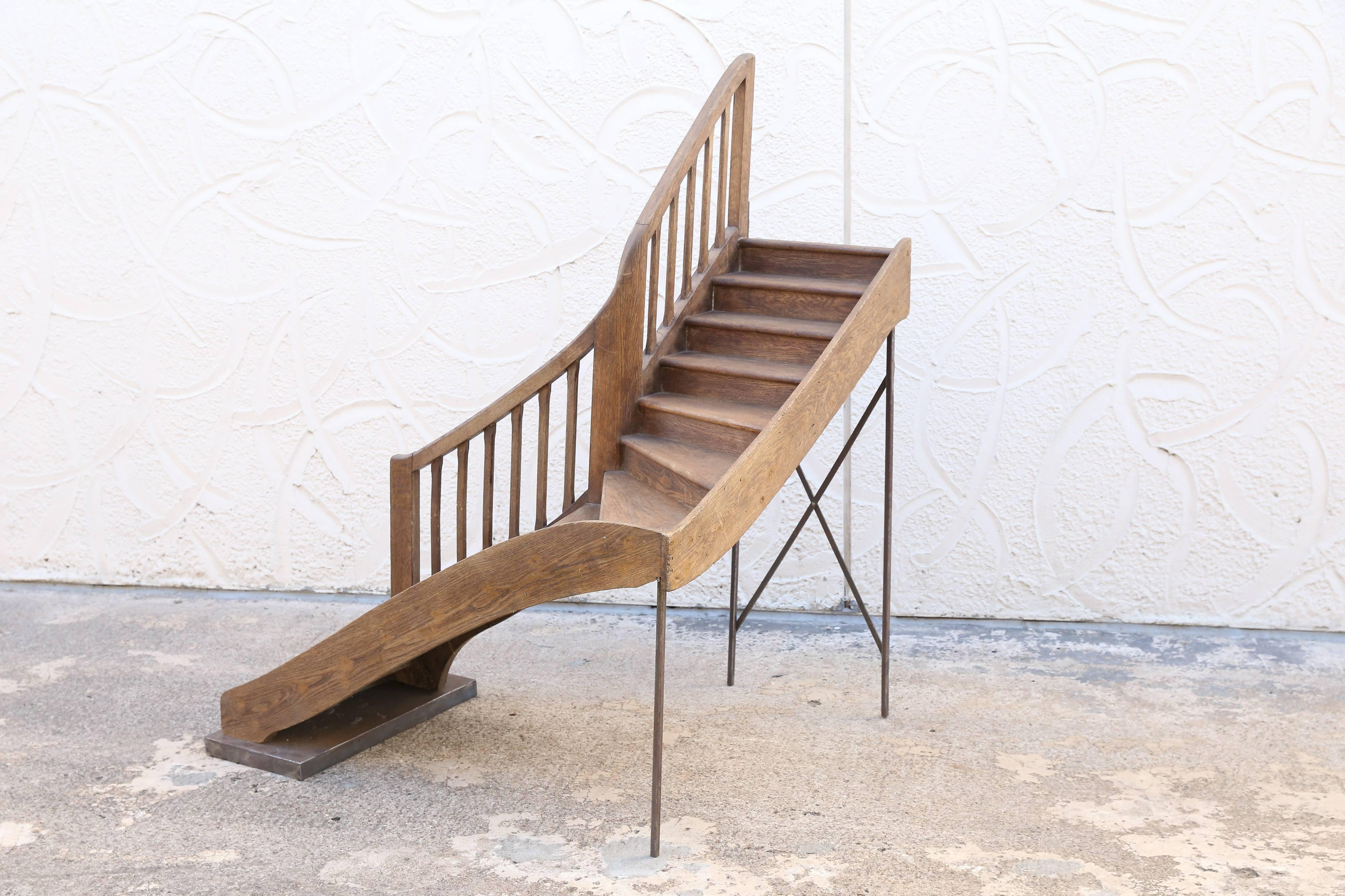 A beautifully constructed wooden staircase model resting on a metal base and legs. The graceful curve of the railing and the bullnose tread nosing are testament to the maker's skills. While perfect for displaying plants or objects d'art, it is when