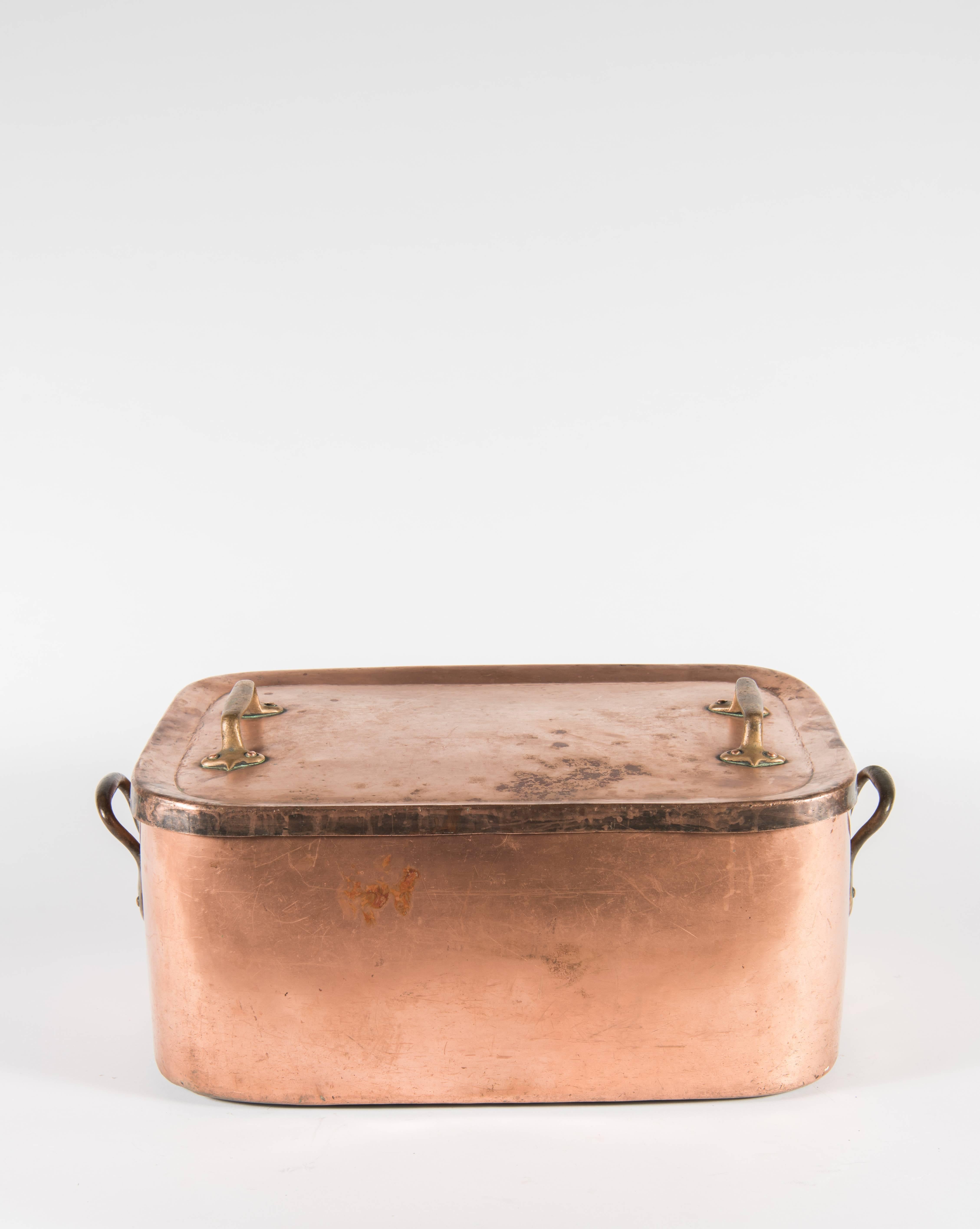 A handsome copper daubiere or braising pot from France. Copper sheets have been shaped and joined with dovetail joints which are still visible. Heavy copper or brass handles are held on with copper rivets. The lid, which is 1 inch deep, does not fit