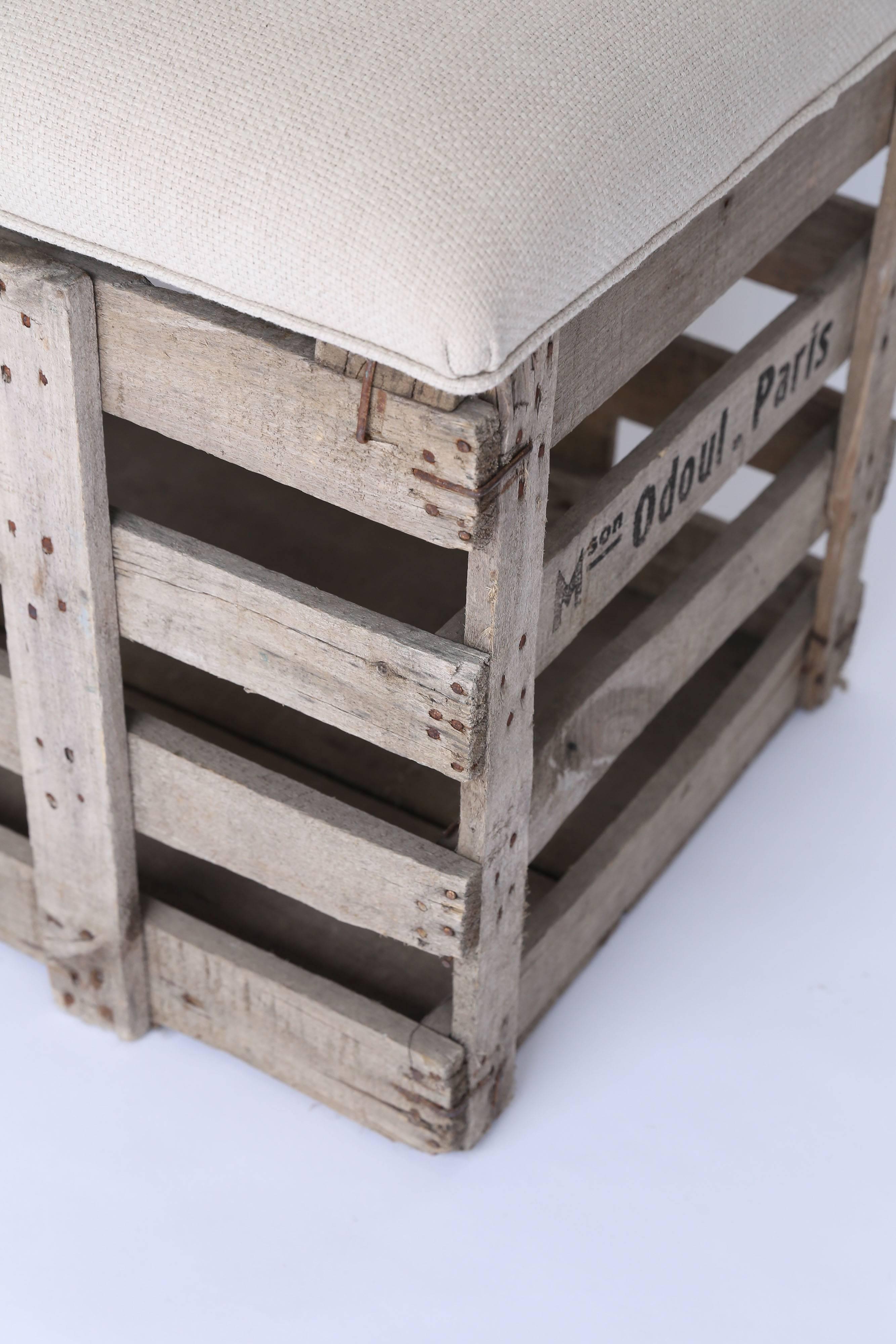 An old crate from France, marked M O'doul, Paris, fitted with a removable padded top creates a fun and useful bench with storage. The top is upholstered with an off-white linen blend. Sturdy and strong.