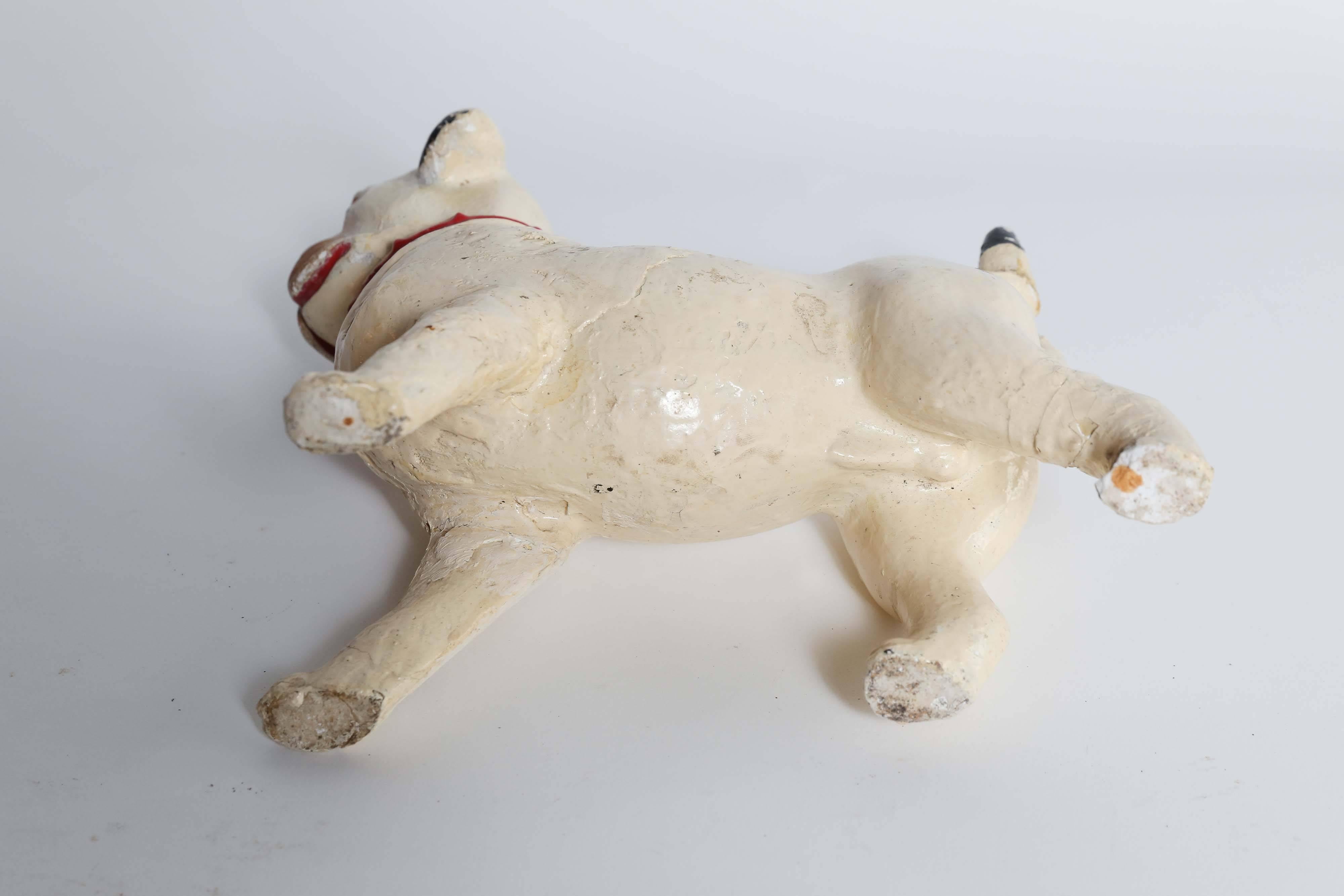 For the lover of pugs, a vintage glazed plaster statue from France. This adorable fellow with a cream, black and brown body sports a red collar, a proud stance and a precious face. There has been a repair at the tail that takes nothing away from the