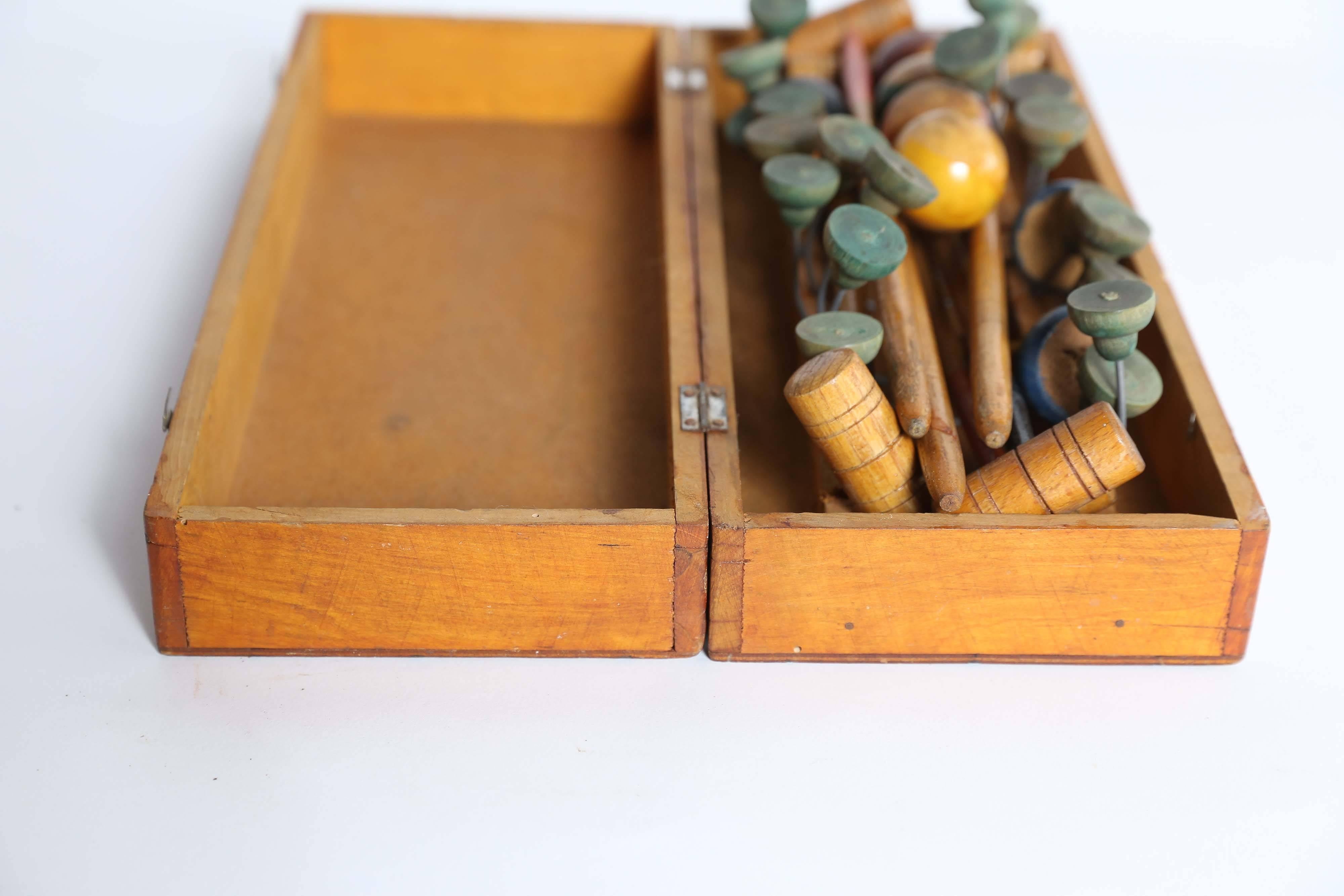 An early 20th century tabletop croquet game with six mallets, five balls, ten wickets and two pegs in the original box. A popular parlor game during the Edwardian and Victorian Eras, this set from the early part of the last century will delight the