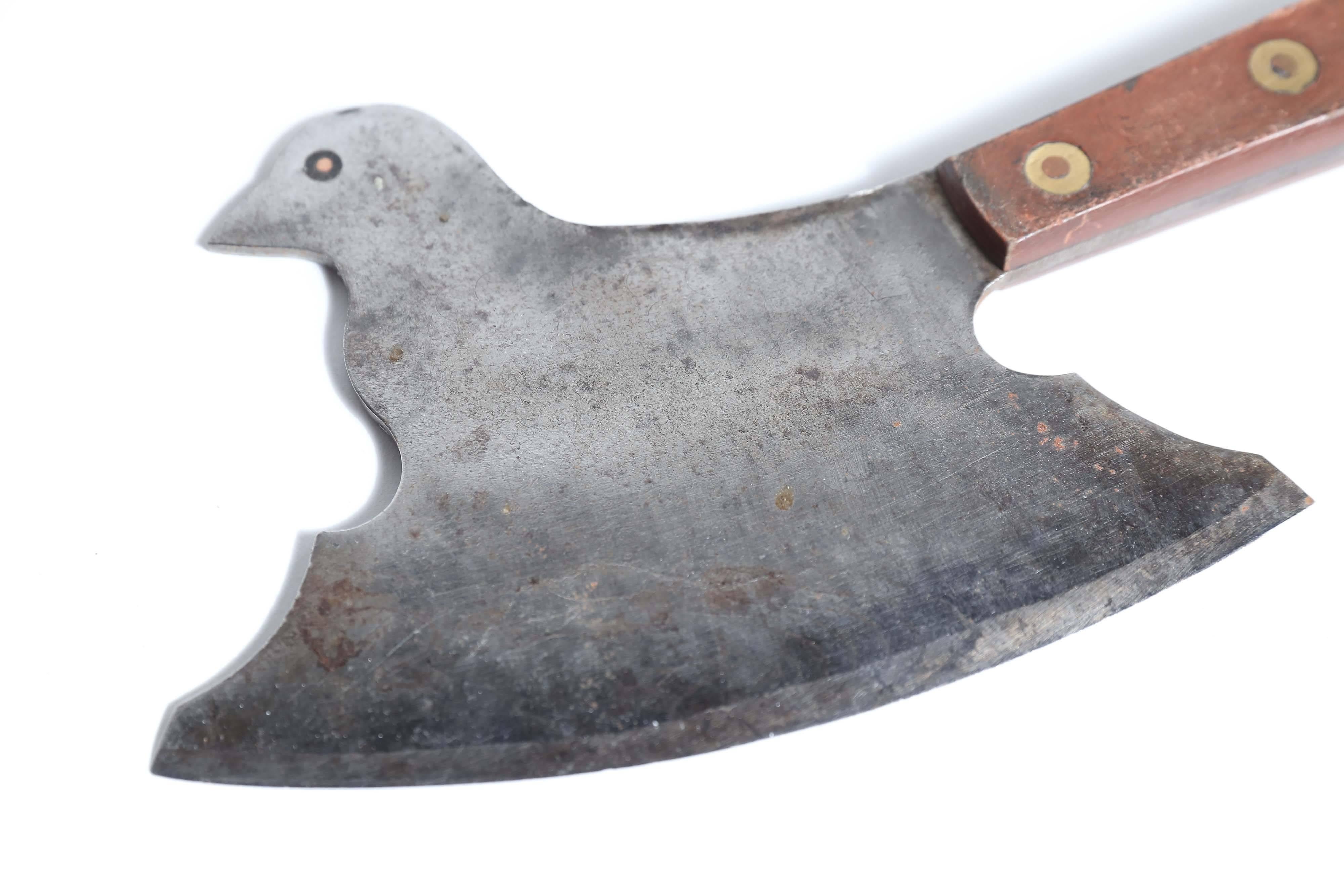 A delightful figurative butcher's cleaver from France in the shape of a bird. Measure: With a 7.5 inch blade, the integral handle has wooden scales attached with brass and copper rivets. The bird's-eye is copper.