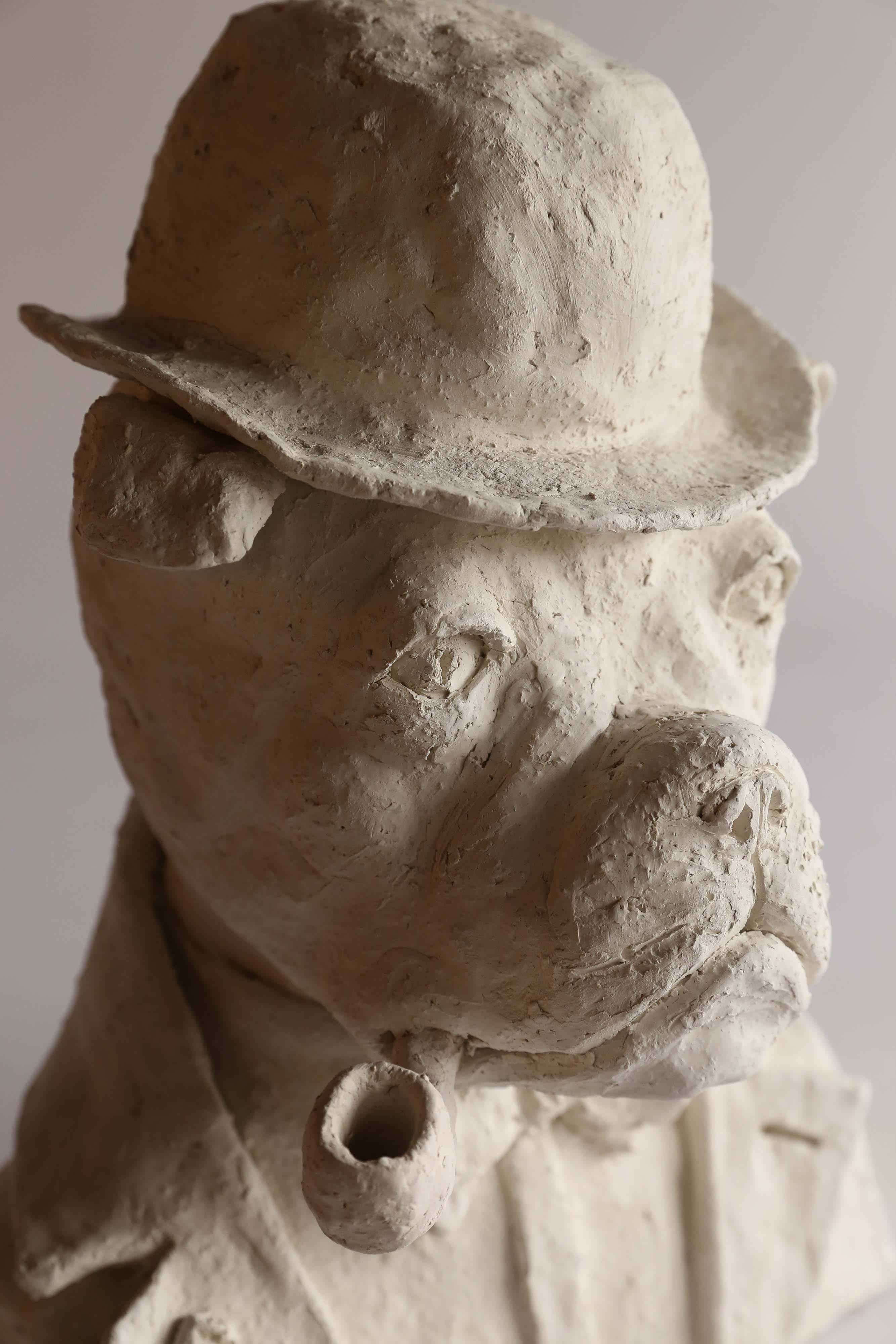A professorial bulldog smokes his pipe as he contemplates the world. Found in France, this delightful plaster bust is signed LL.
