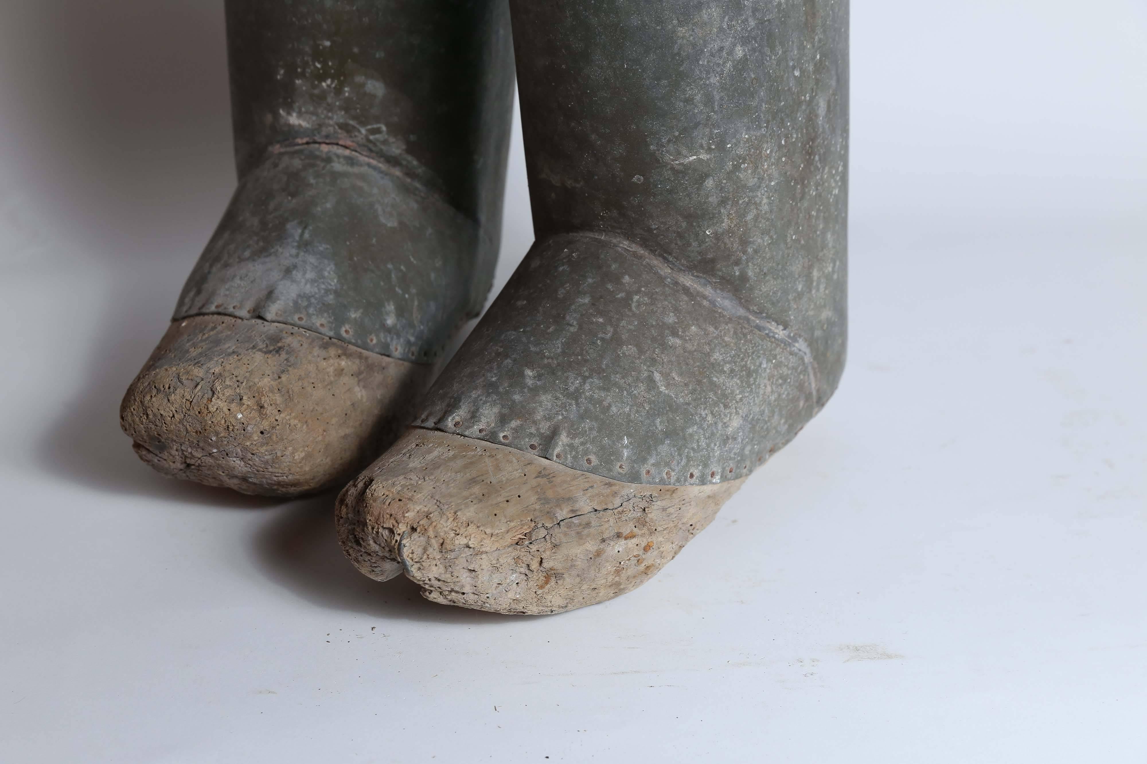 A rare pair of 19th century zinc and wood clog boots found in France. Zinc uppers have been shaped and nailed to the balsa wood clogs. Reputedly used by eel fishermen to protect the lower portion of their legs while spearing eels. The balsa bottoms