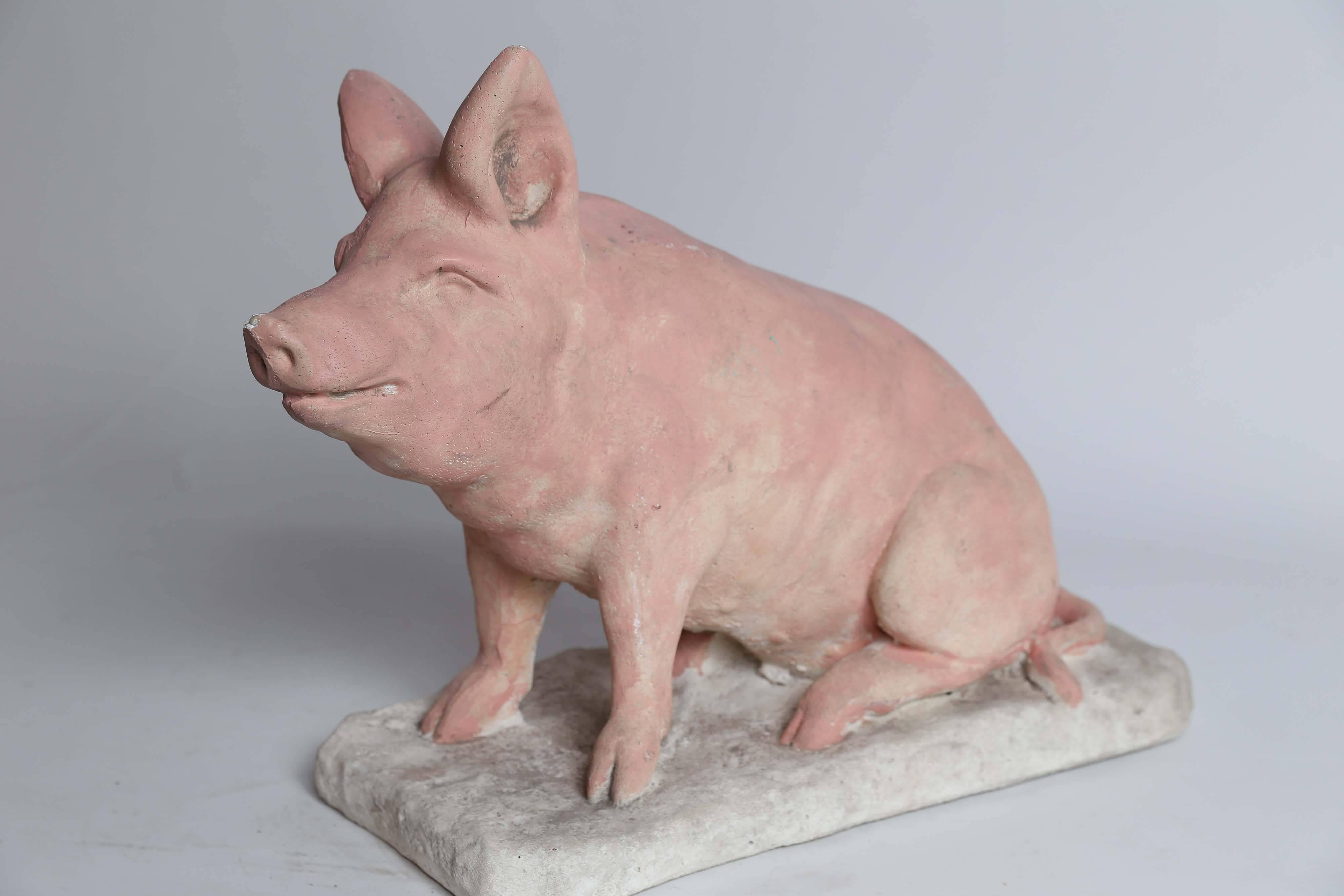 A pudgy pink pig made of concrete will take his place in your kitchen, your garden, or wherever you want a spot of whimsy. A chip on his nose and a small scrape on his ear are his only flaws.