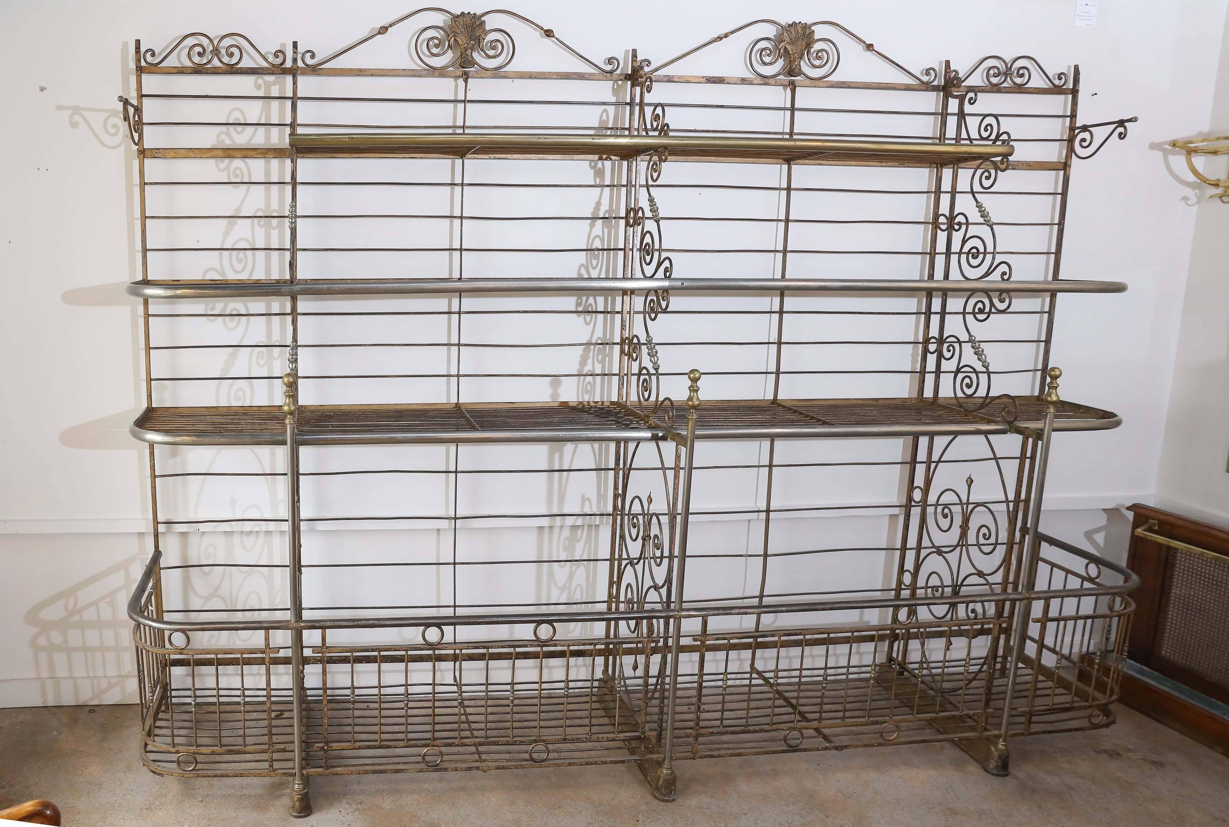 A truly outstanding bakers rack marked 'Lyon, France'. Grand in scale, this iron and brass rack has a large open gallery at the bottom with three tiers above. Intricate scroll work adorns each section and brass wheat medallions embellish the top.