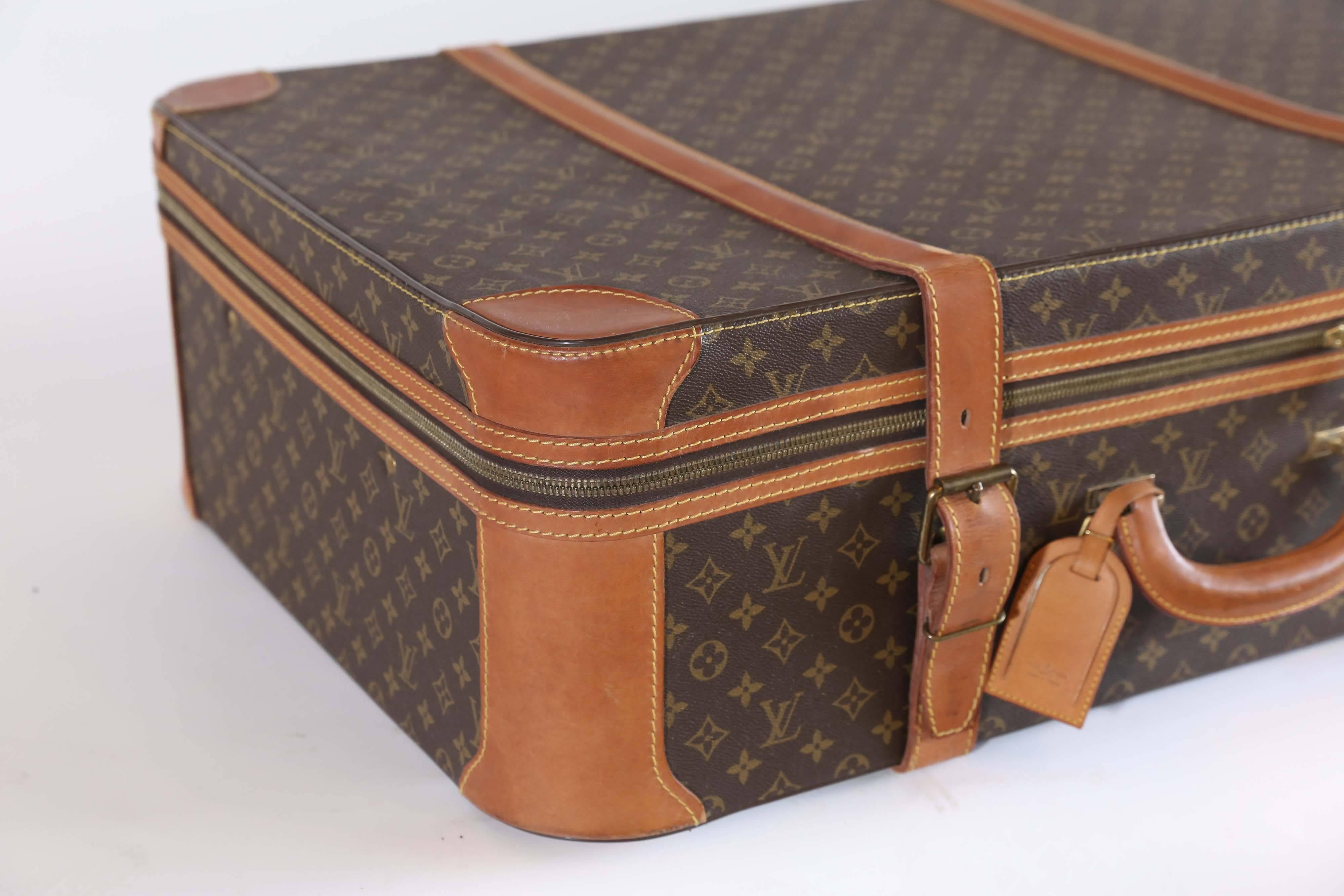 A well-loved vintage Louis Vuitton suitcase. Manufactured in April, 1985, this 32-year-old icon has wear consistent with age and thoughtful use. The leather has colored from handling but has only minor scuffing. The zipper works without snagging,
