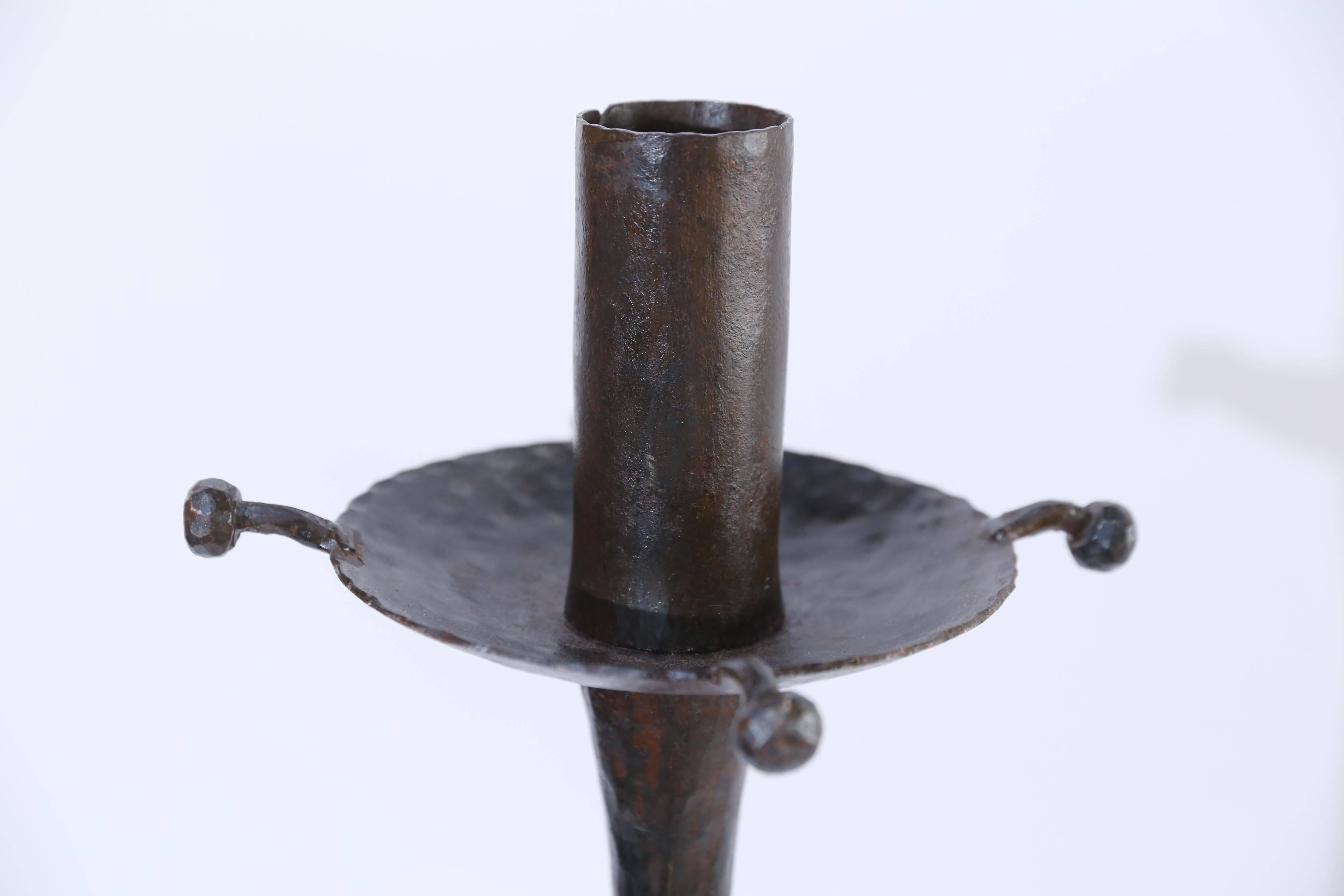 Standing 56 inches tall on a tripod base, this forged and hammered iron candlestick from France is a sensational piece of ironwork weighing over 30 lbs.