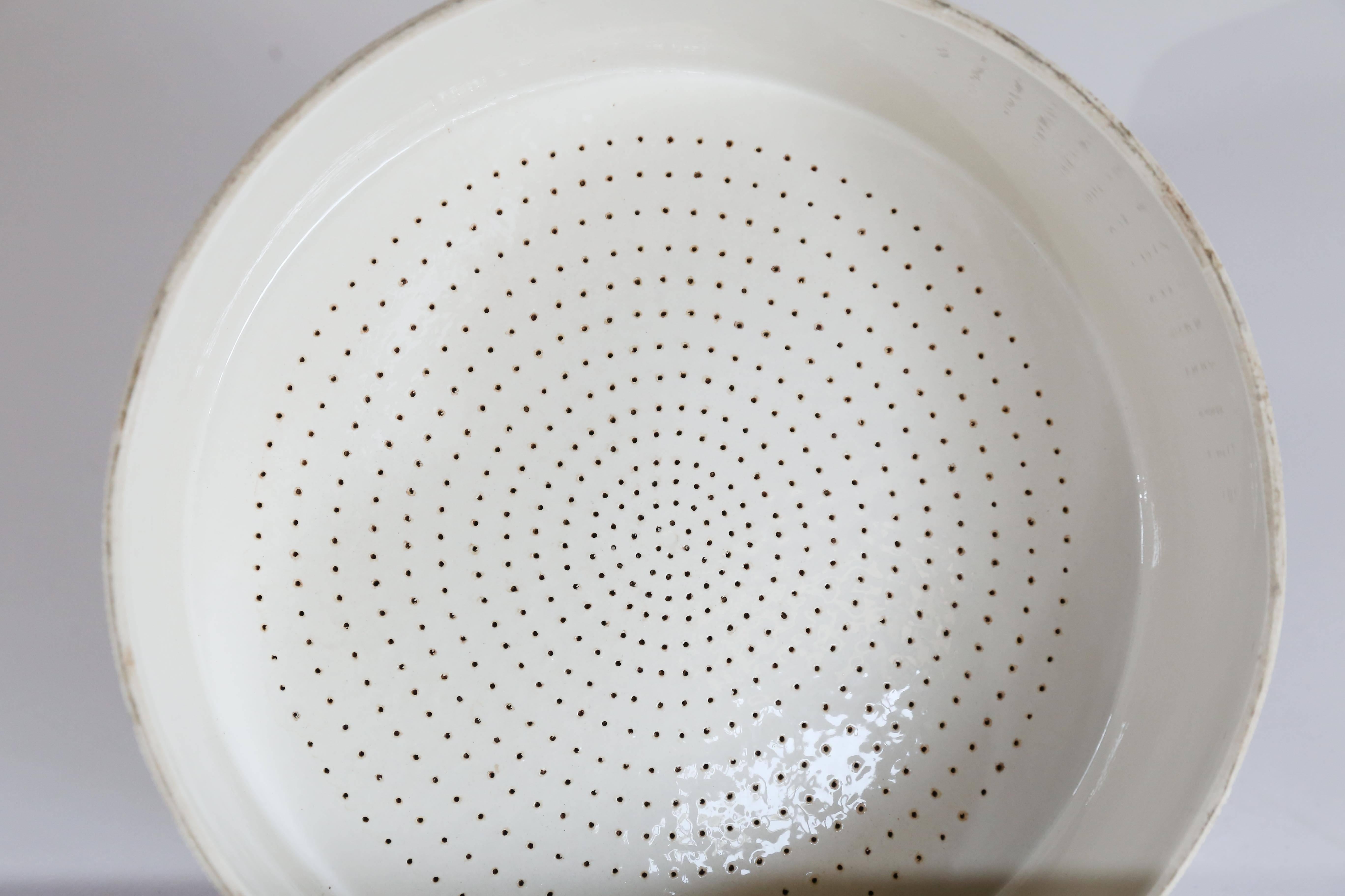 A large porcelain Büchner funnel from France. Although a Büchner funnel is a piece of laboratory equipment used in filtration, the visually interesting perforations and the strong sculptural quality of the piece makes for a dramatic and interesting