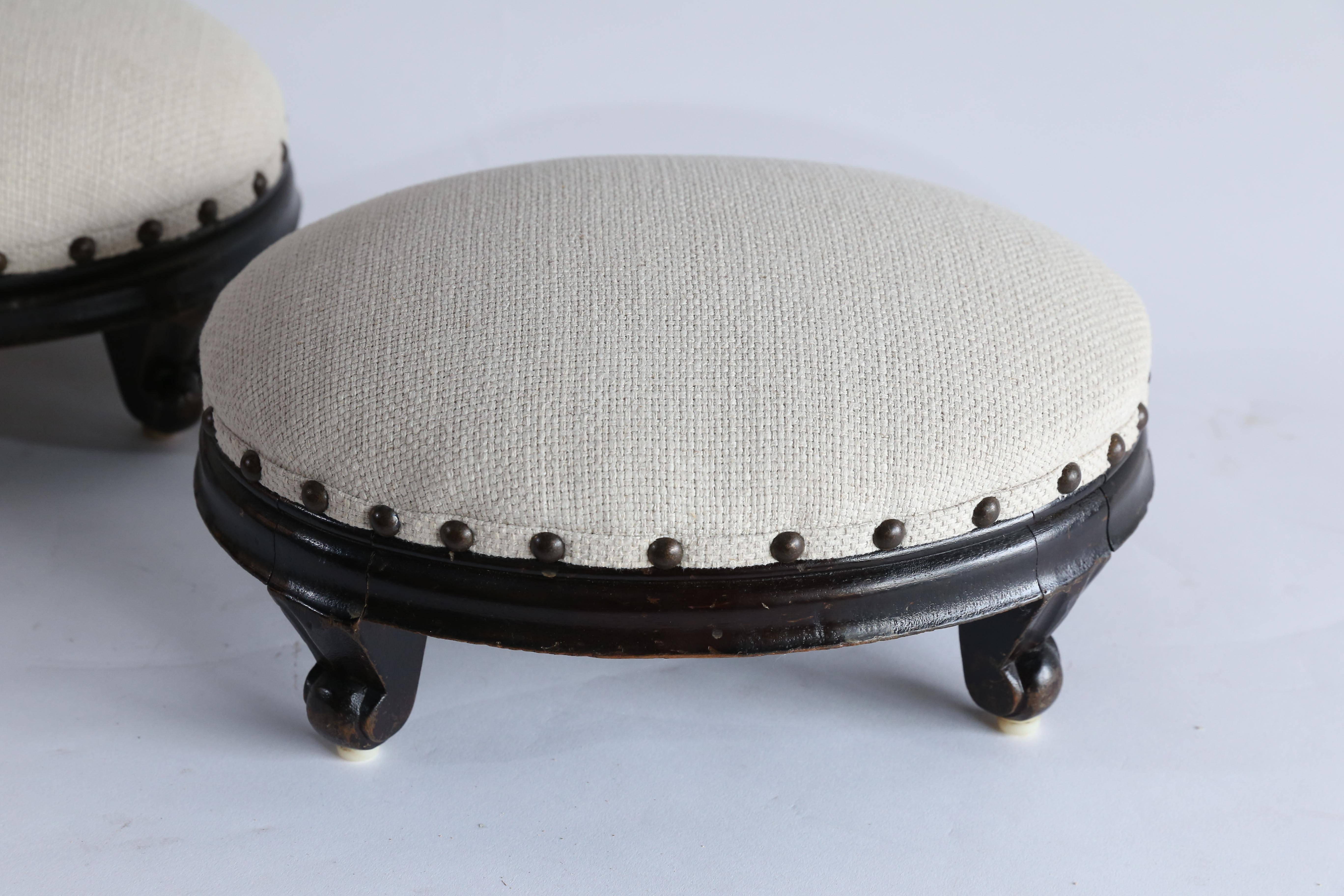 A lovely little oval foot stool of dark wood with scroll feet found in France. Newly upholstered in a cream linen blend enhanced with brass nail heads.
Sold separately, two available.
