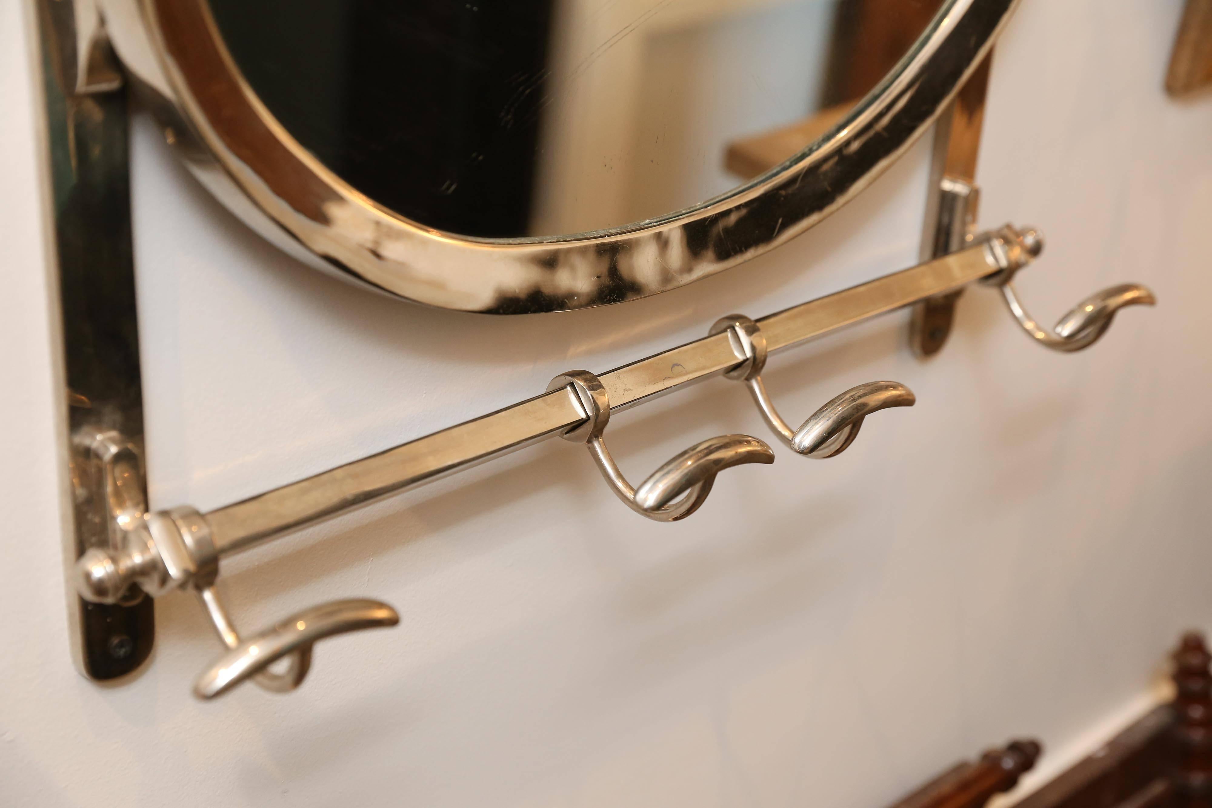 From France, a striking chrome hanging hat/coat rack with a stationary mirror. With four sliding hooks for coats and an upper shelf for hats, this piece has tremendous impact and evokes a more glamorous time. The surface has only minor aging and