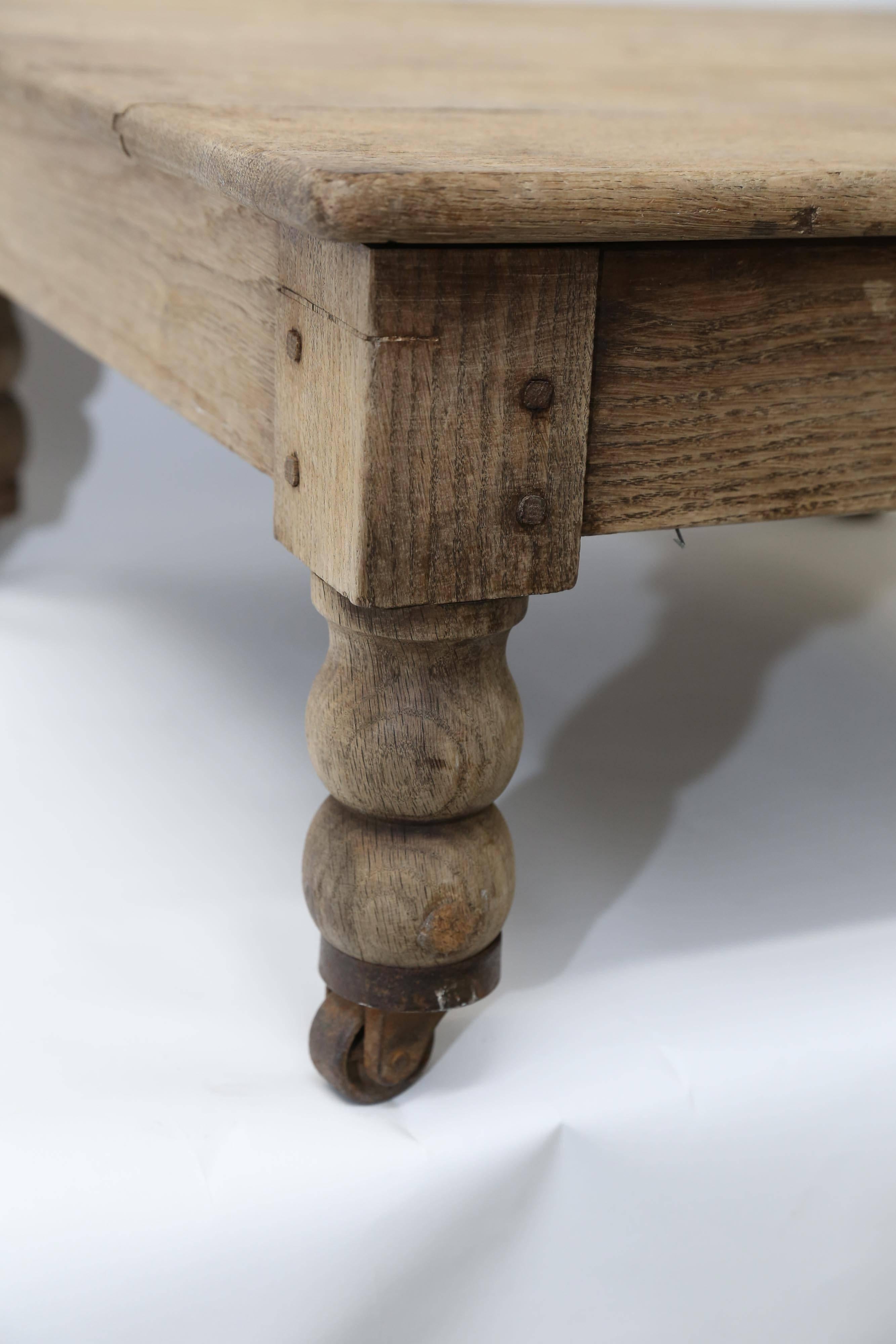 A small wood table with turned legs on metal casters found in France. Made by hand, the apron is attached with small square wooden pegs that make a delightful detail on the unfinished wood. A little table with a big personality!