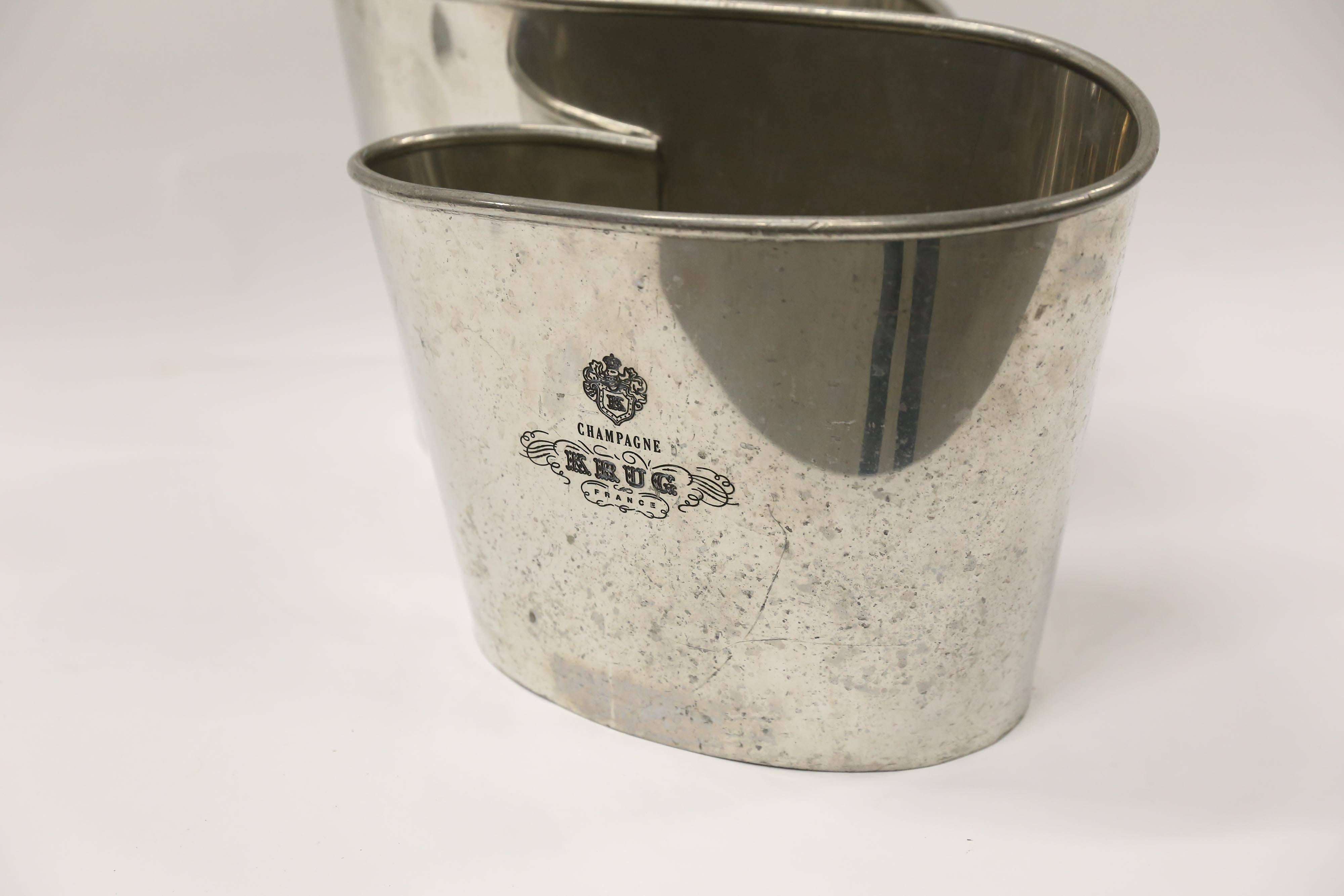 An infinity shaped double champagne cooler from the House of Krug to hold and chill your champagne or other wines. Made of pewter, the Krug emblem is engraved on both sides. Scratches and pitting on major surfaces. One of the harder-to-find Krug
