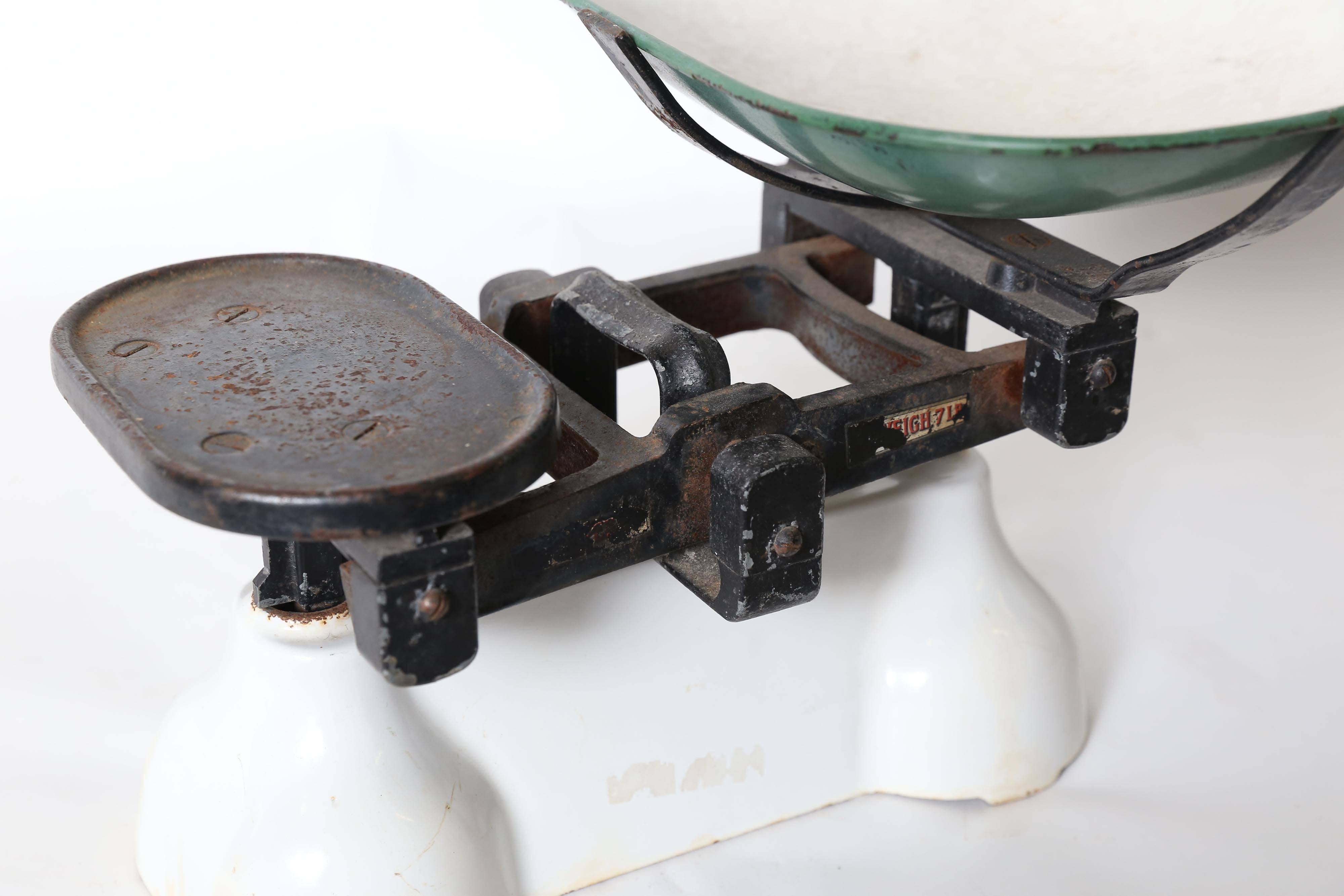 A small 7 lb. Roberval balance scale found in France. A white enameled metal base of considerable weight supports the plate and pan mechanism. The pan measures 9.5 inches x 13.25 inches x 2.5 inches with a white enameled interior and green enameled