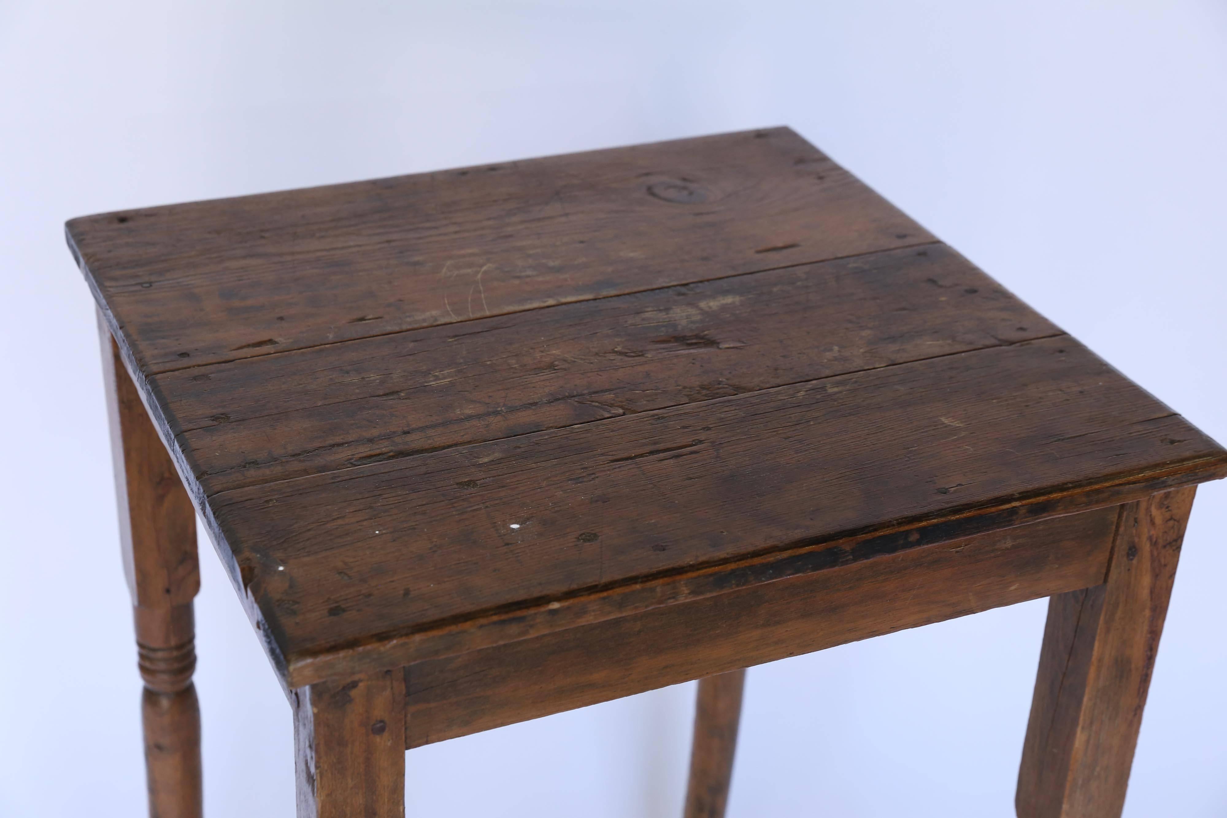 A rustic side table in walnut from France. With an X-stretcher and tall spindle legs, this lovingly handmade table has an inviting warmth and a noble presence.
