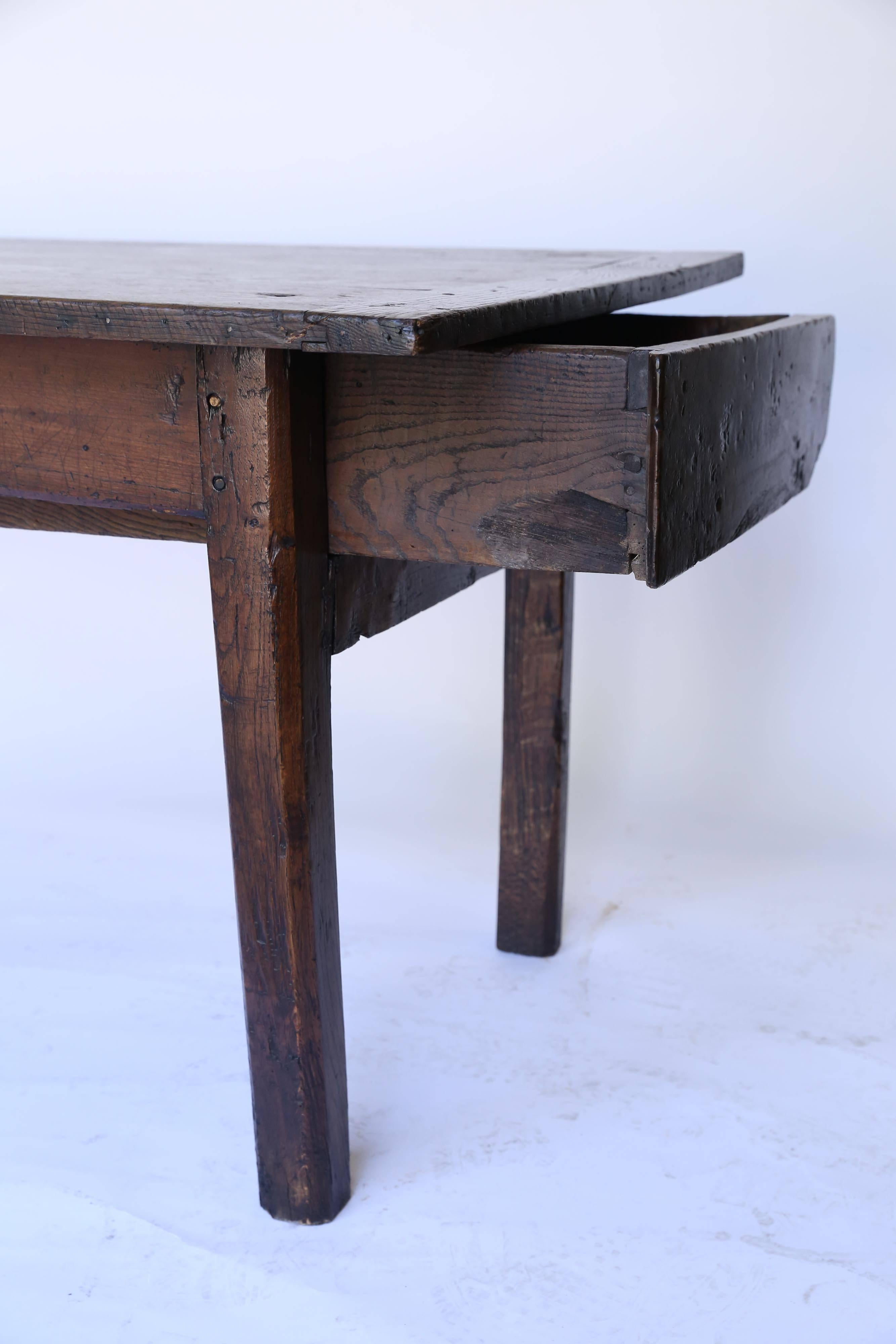 Made by hand, Circa 1820, an old farm table from France with two drawers. The drawers measure 20 inches wide by 22 inches long by 5.25 inches deep. Wonderful dark patina.