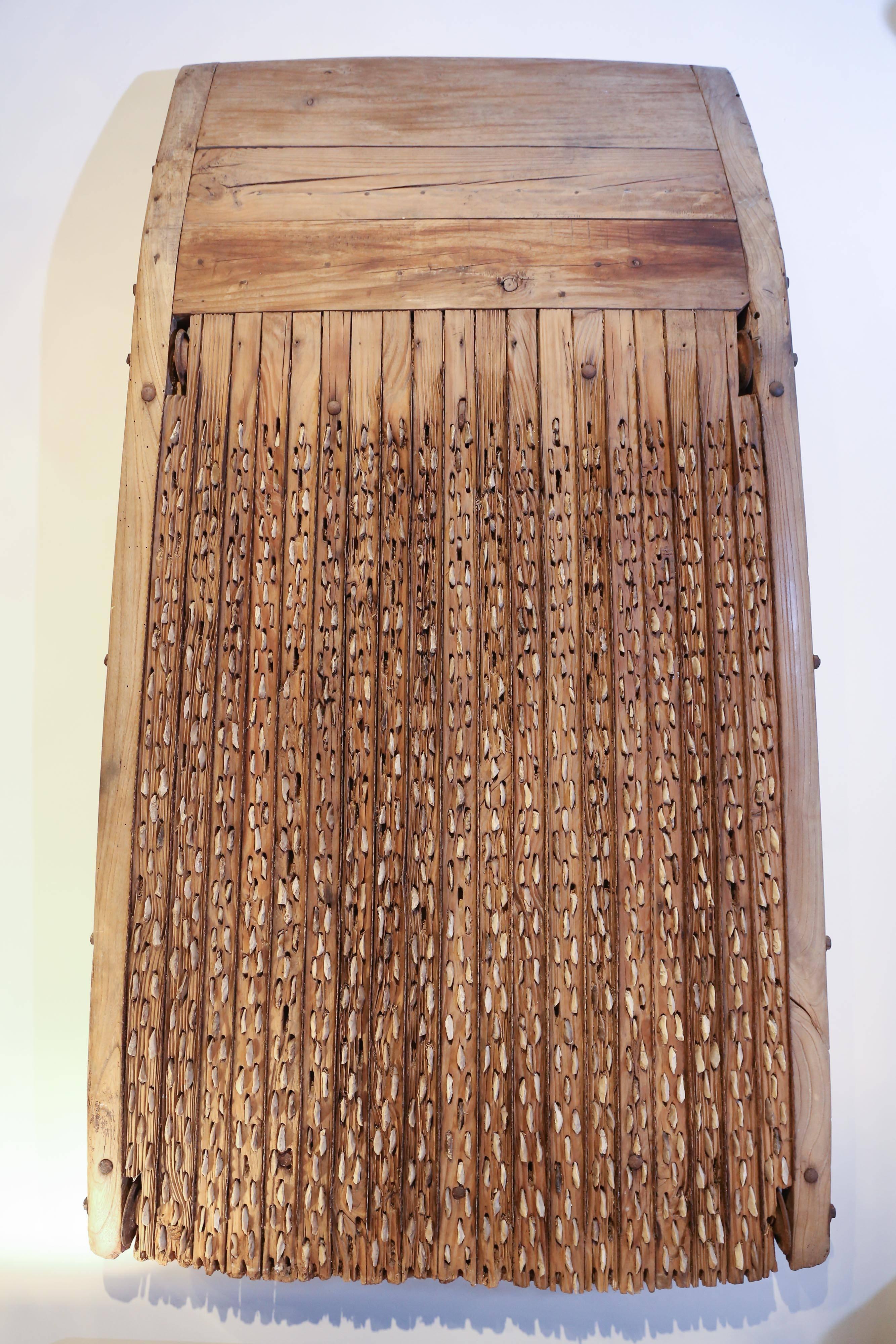 Antique tribulum or grain threshing tool used in the mountains of France. A farm animal would be used to pull the sledge across the ground while the embedded stone chips or flint are used to aid in the separating process. These would have been used