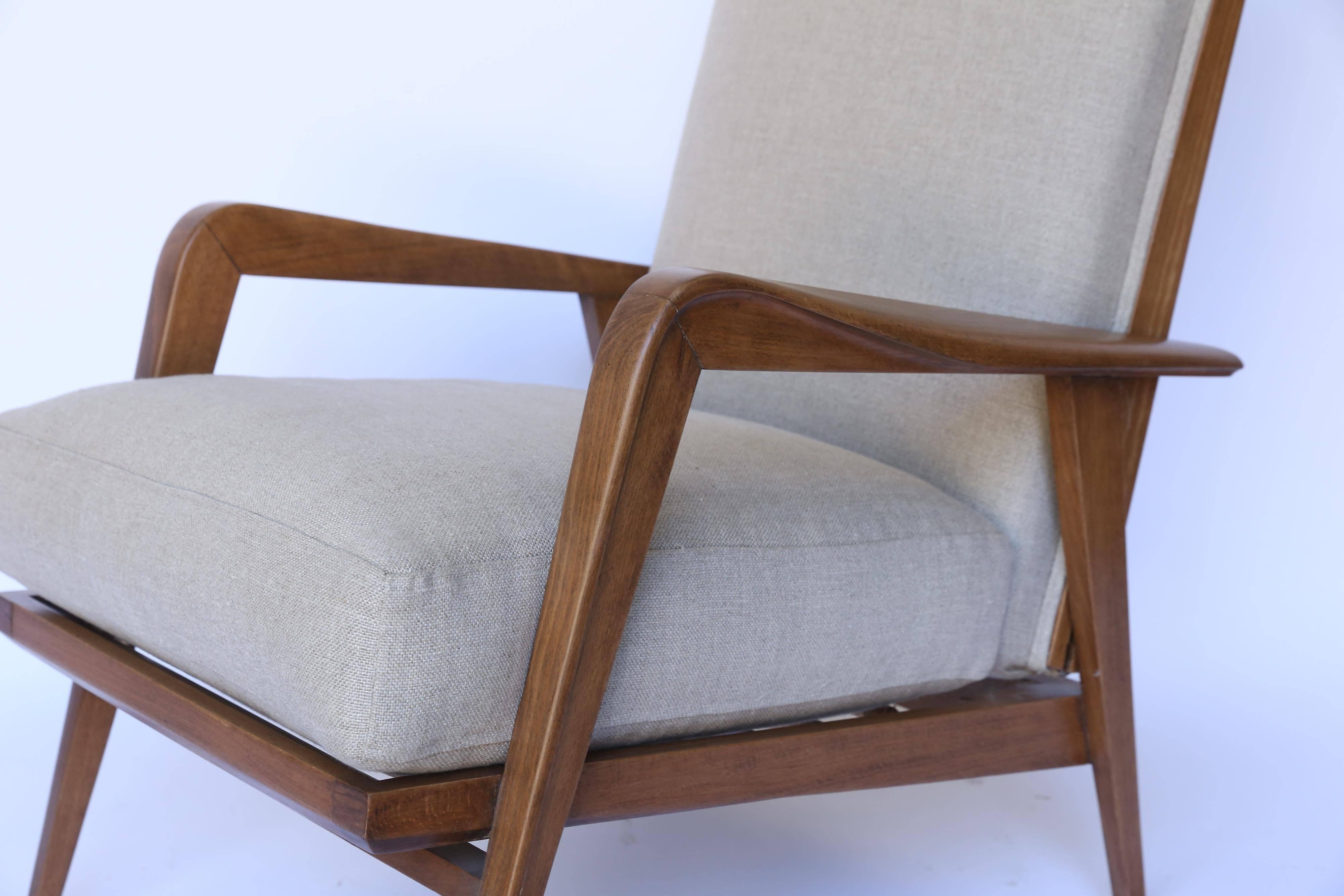 Newly upholstered in linen, a wonderful pair of Danish Modern reclining chairs in the style of Milo Baughman. With an attached back and loose cushion seat, these sophisticated chairs lend themselves to a variety of living spaces. Strong and sturdy