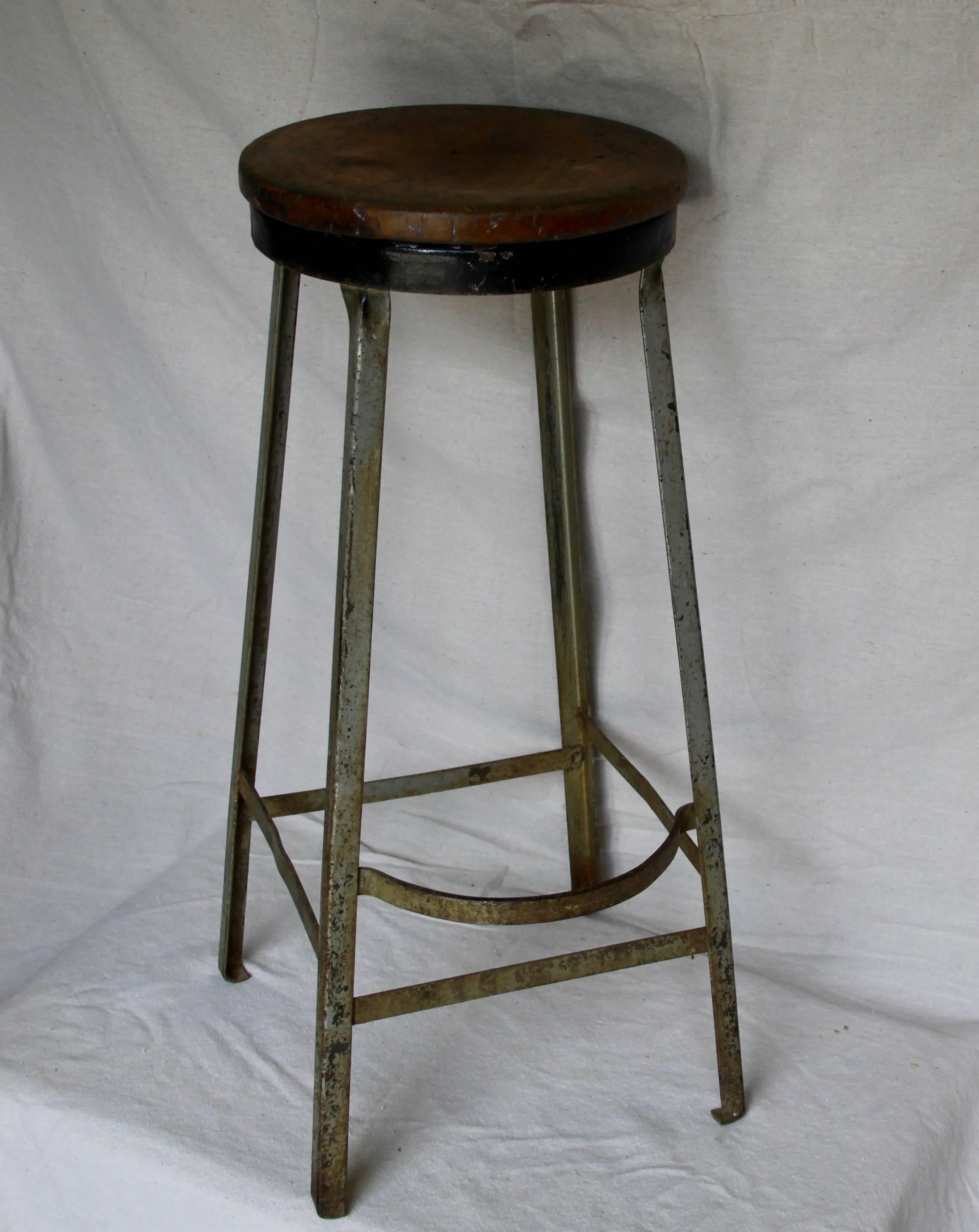 A wonderful vintage stool found in France. A 13 inch diameter wood seat on black metal with grey metal legs and footrest. Great character.