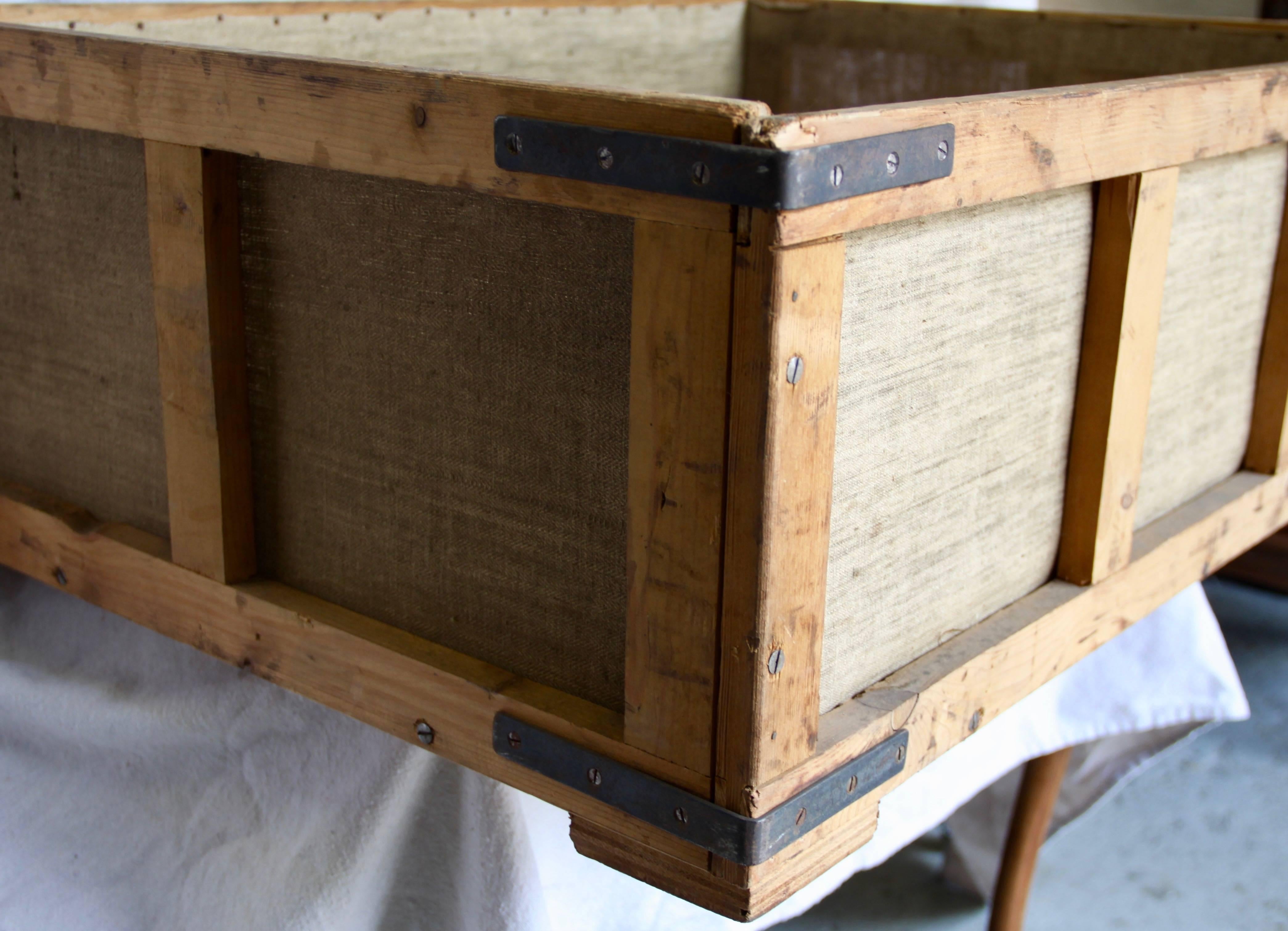 An unusual wooden box consisting of a heavy wooden frame with fabric sides and bottom from a cigar factory in Europe. Although found in France, the box most likely came from Germany and was used to hold cut tobacco. Solid construction and iron