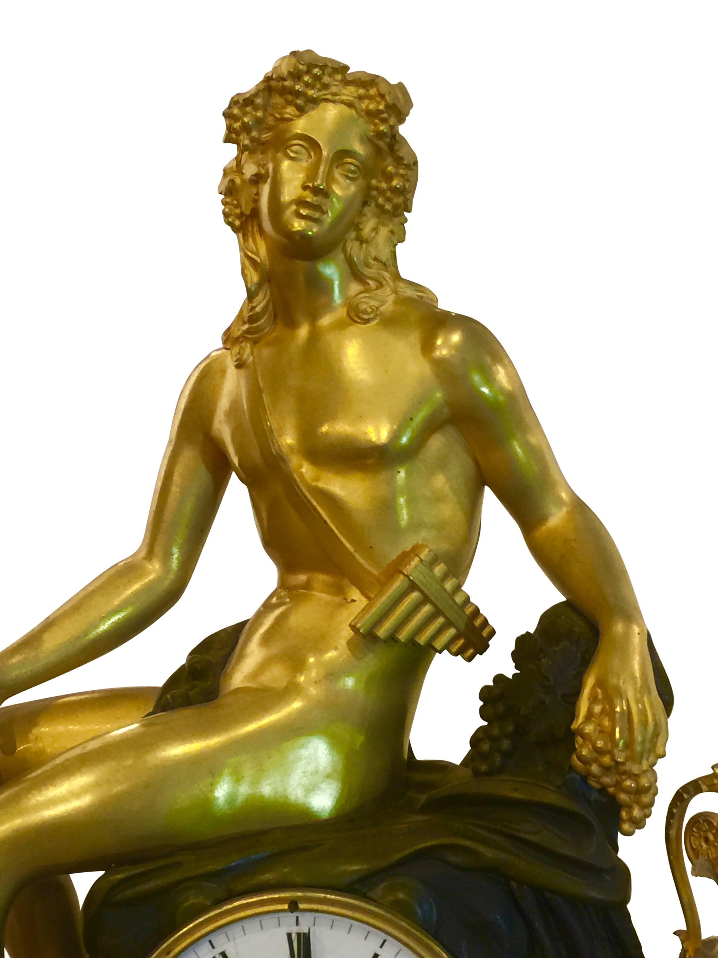 French bronze clock, early 19th century, partially fire-gilded, half-stroke on bell, pendulum amit thread suspension, eight-day work. Bacchus as a beautiful youth in the loincloth with a pan flute. In his hand he holds a ceremonial stick entangled