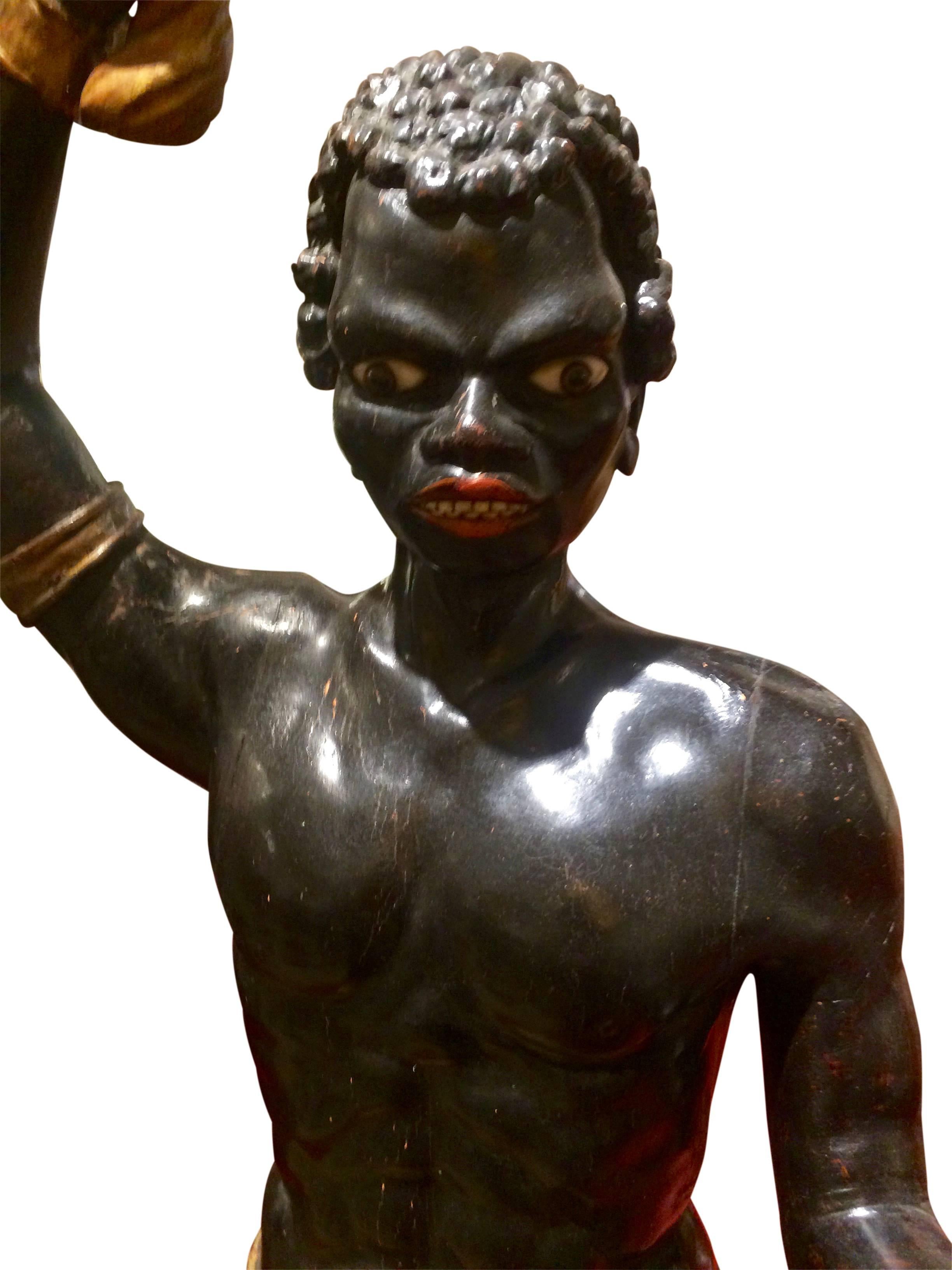 Black moor figure circa 1820, carved in wood, painted in color, with glass eyes. In the right hand you can put a candle.
Measures: Height 142 cm.