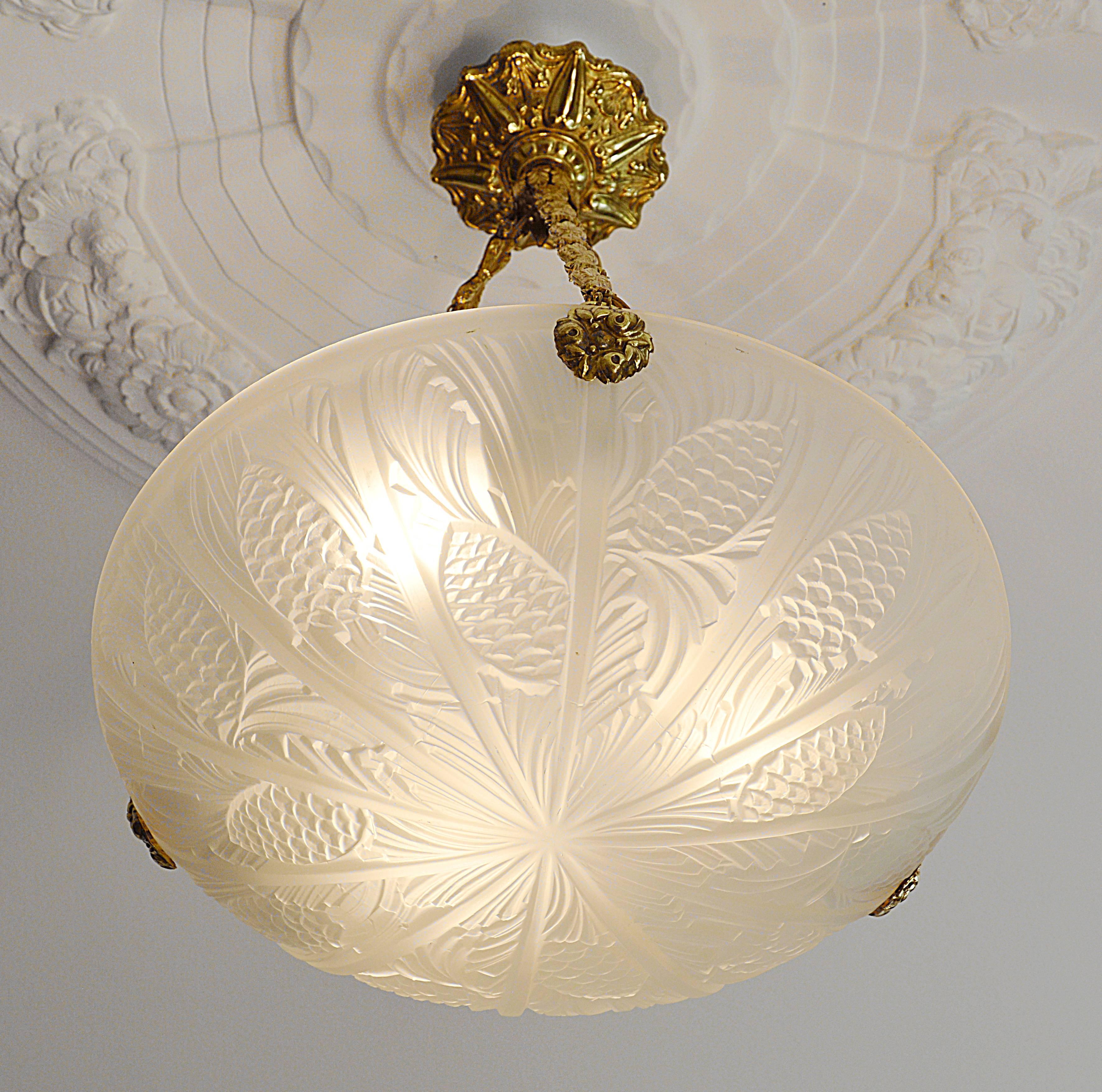 French Art Deco pendant chandelier by Daniel Drancourt, seven rue Bleue, Paris, France, 1929. White frosted molded glass shade with a pine-cone pattern. Old and genuine brass and embossed metal fixture. Can be compared with the Muller Freres,