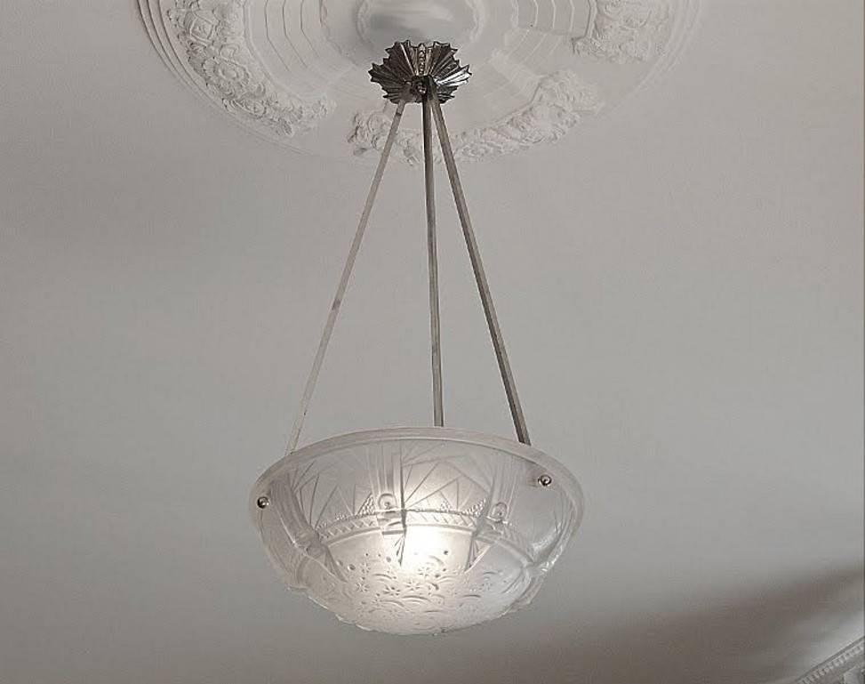 French Art Deco chandelier by Muller Frères (Luneville), circa 1925.

White molded glass shade, nickel-plated metal fixture.

Measures: Height 28.7