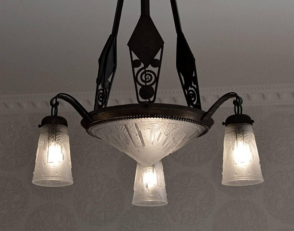 French Art Deco chandelier by Muller Frères (Luneville), circa 1925. One of the most precious models by Muller Frères. The geometrical pattern of the white frosted glass shades is very well defined with sharp edges. These shades come on a refined