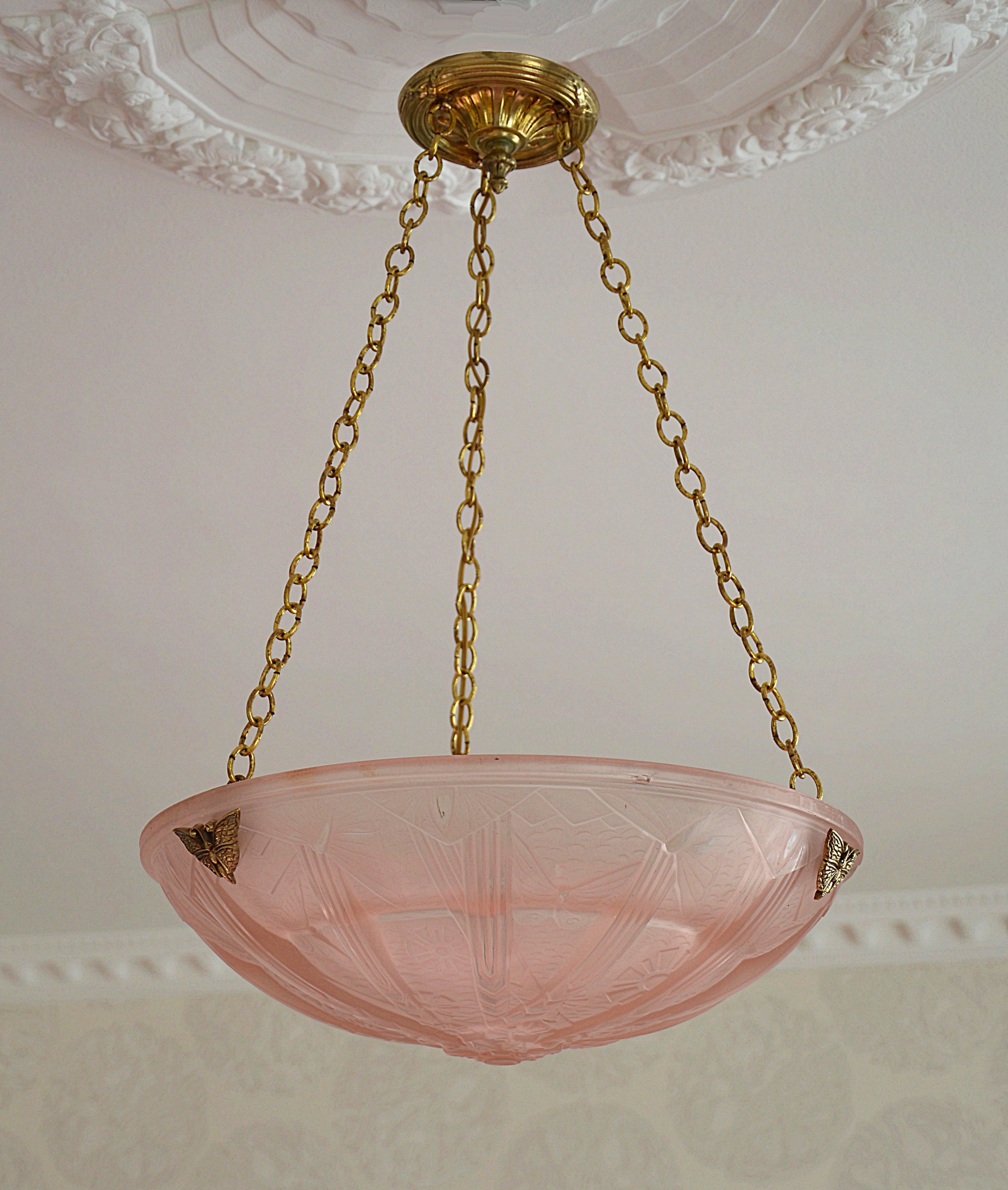 French Art Deco pendant by Muller Frères, Luneville, circa 1925. Thick pink frosted glass shade with a butterfly pattern. It comes with its original bronze fixture with butterflies too. Signed "Muller Freres Luneville" on the