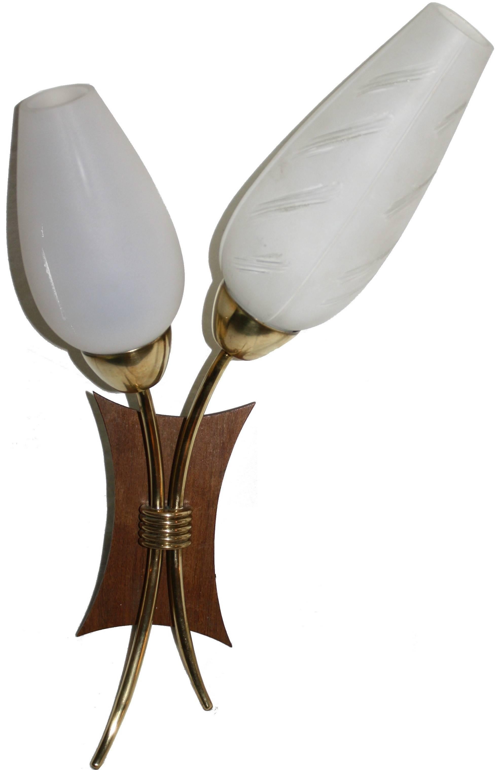 Pair of charming Mid-Century wall sconces made from teakwood and brass with white glass shades.
​
Two of the four shades are decorated and these can be moved between the holders.
​
These lamps give a very sweet and warm ambience in the