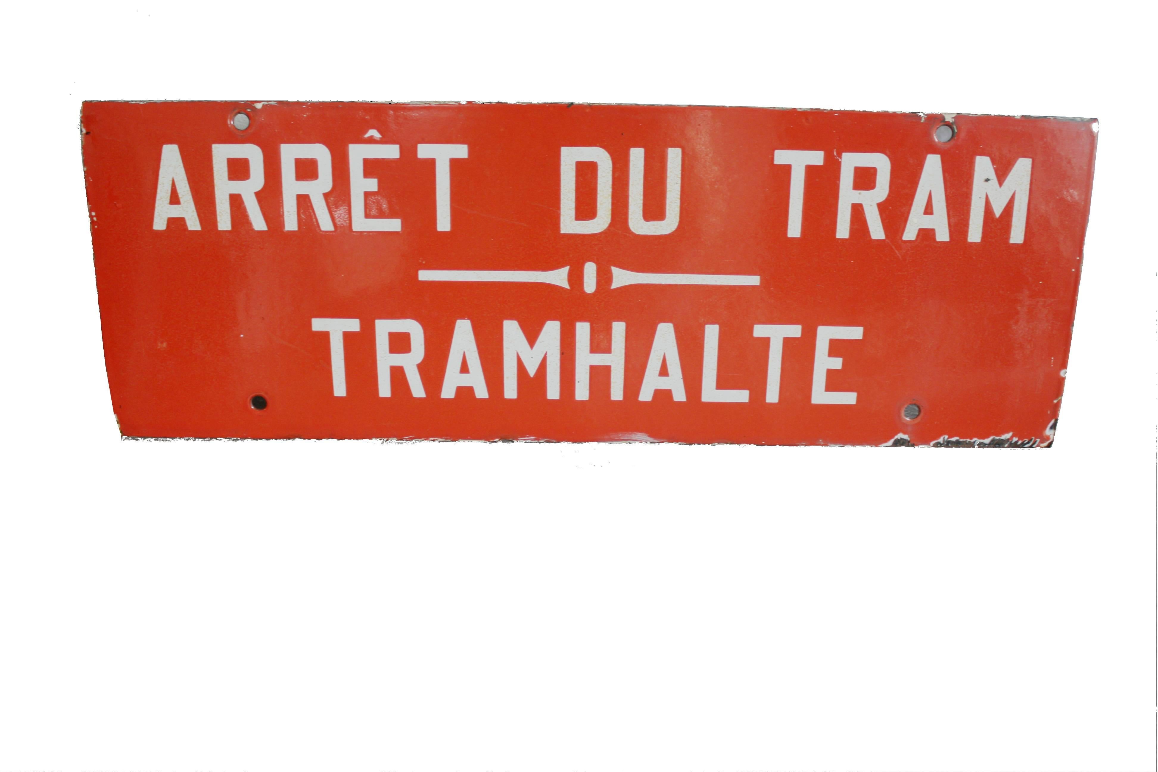 Enamel tram stop sign.

This enamel Signal was salvaged from a old tram station located in the Belgian capital.

It has beautiful wear and tear but is in a good condition with a nice red color and white letters saying tram stop in both national