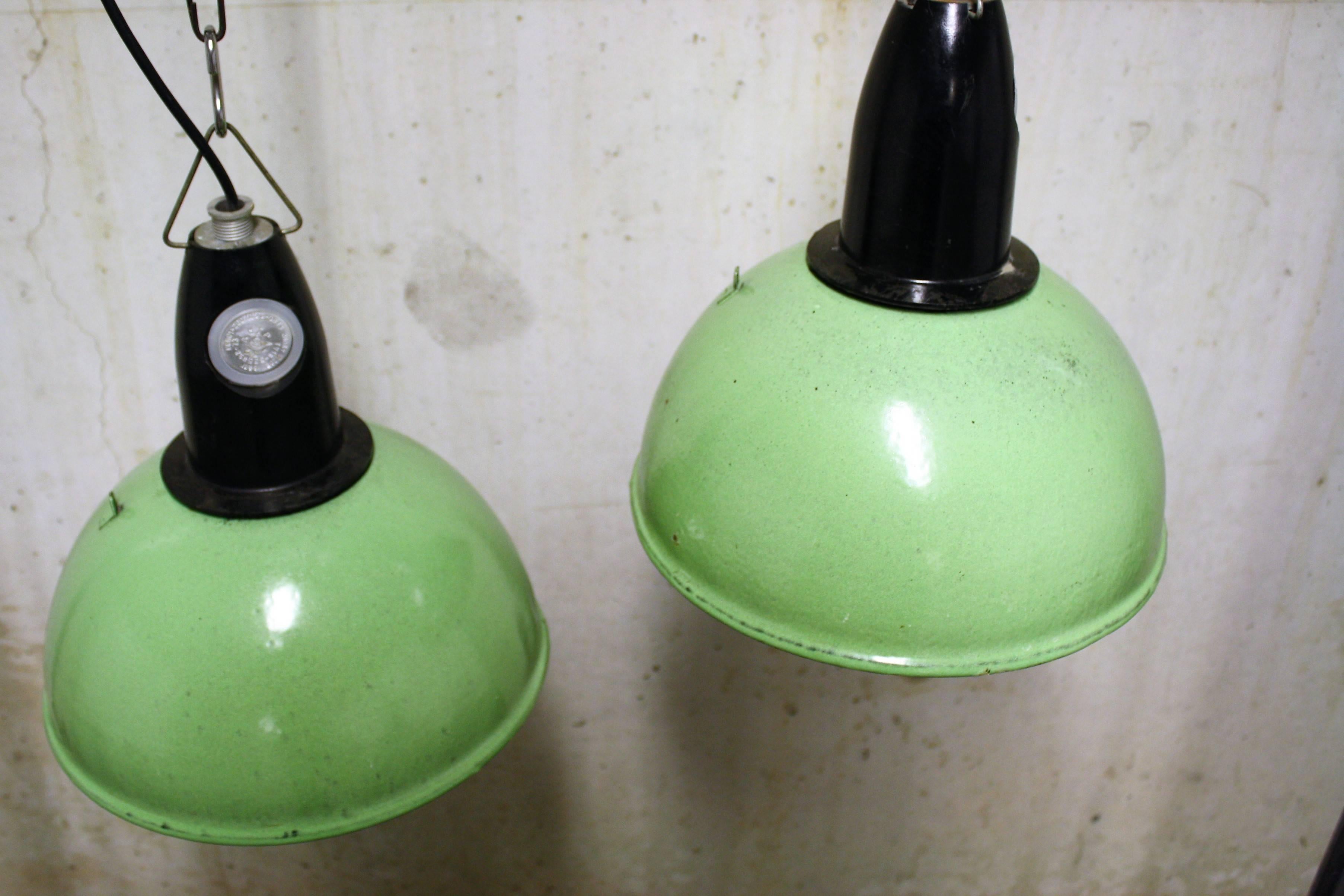 Splendid mint green Industrial pendant lamps made from enamelled metal and bakelite.

This type of lamps was popular in de 20th century due to their easy to produce shape and durability. 

Today these lamps are popular in home interiors, bars,