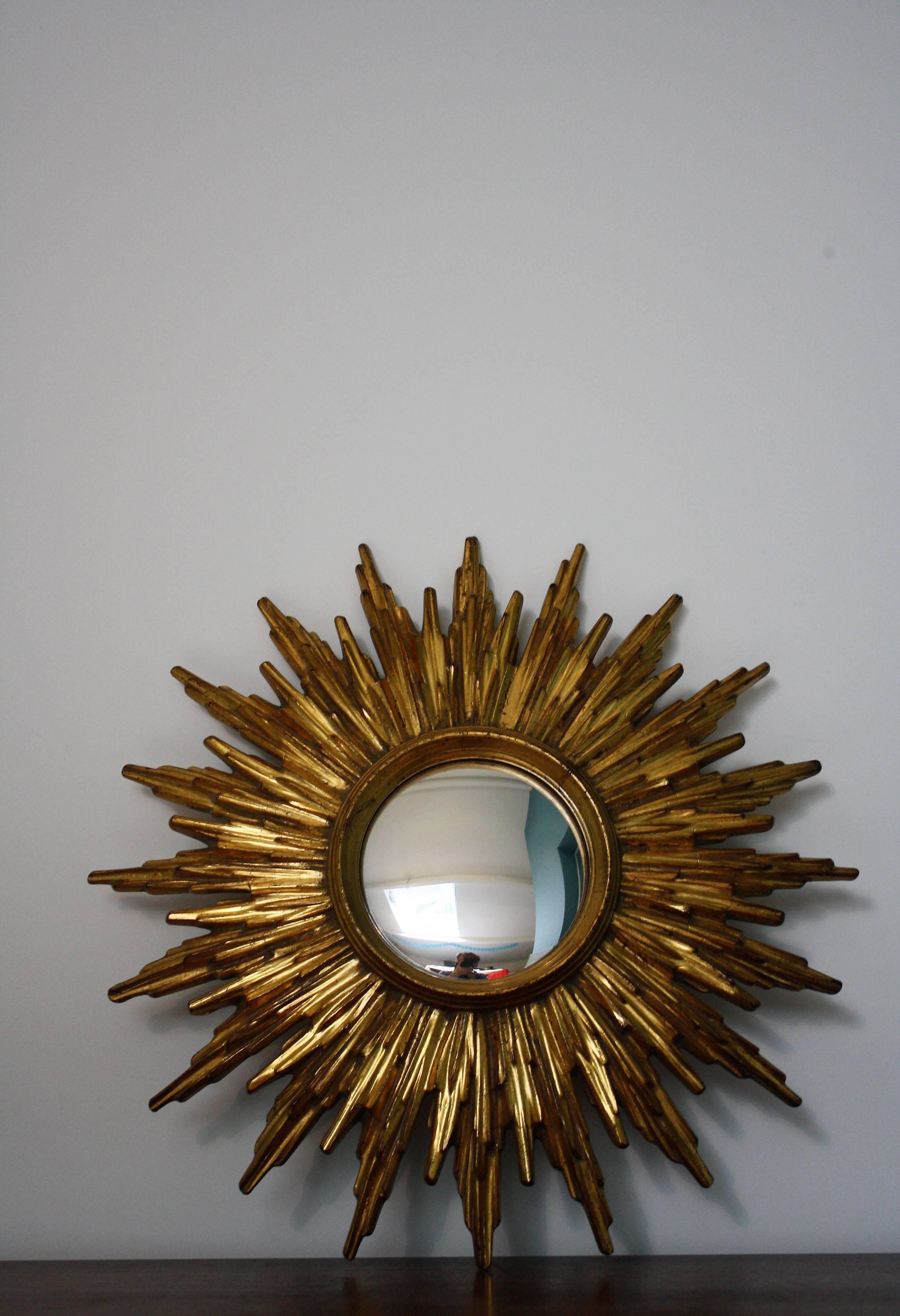 Gilded resin sunburst mirror with convex mirror.

The golden mirror is in a very good condition.

1960s, made in Belgium

Measure: Diameter 37cm/15