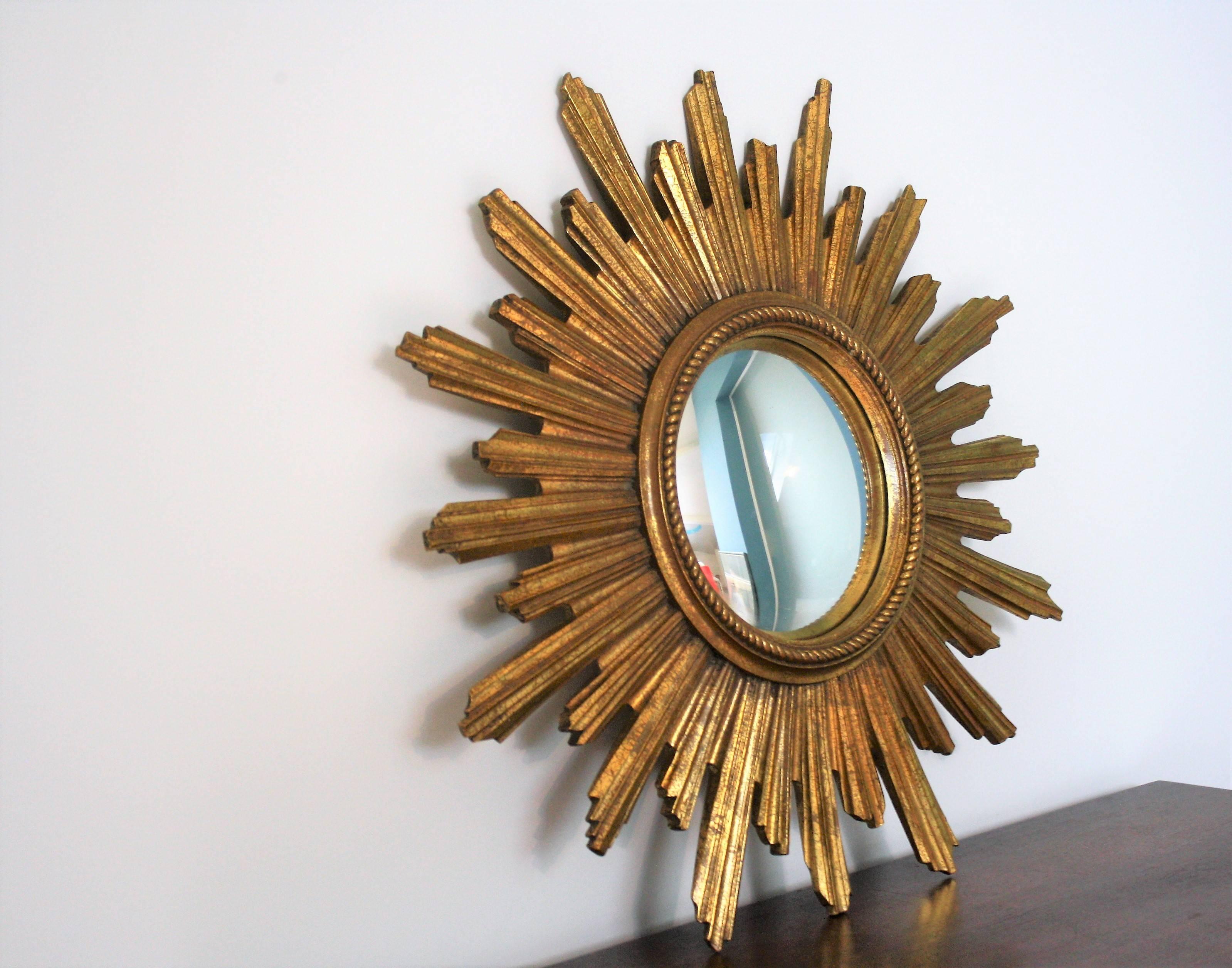 Gilded resin sunburst mirror with convex mirror glass.

The golden mirror is in a very good condition.

The mirror is made by Geratal, a Belgium company.

1960s - made in Belgium

Measures: Diameter 45cm/18"

We have two pieces