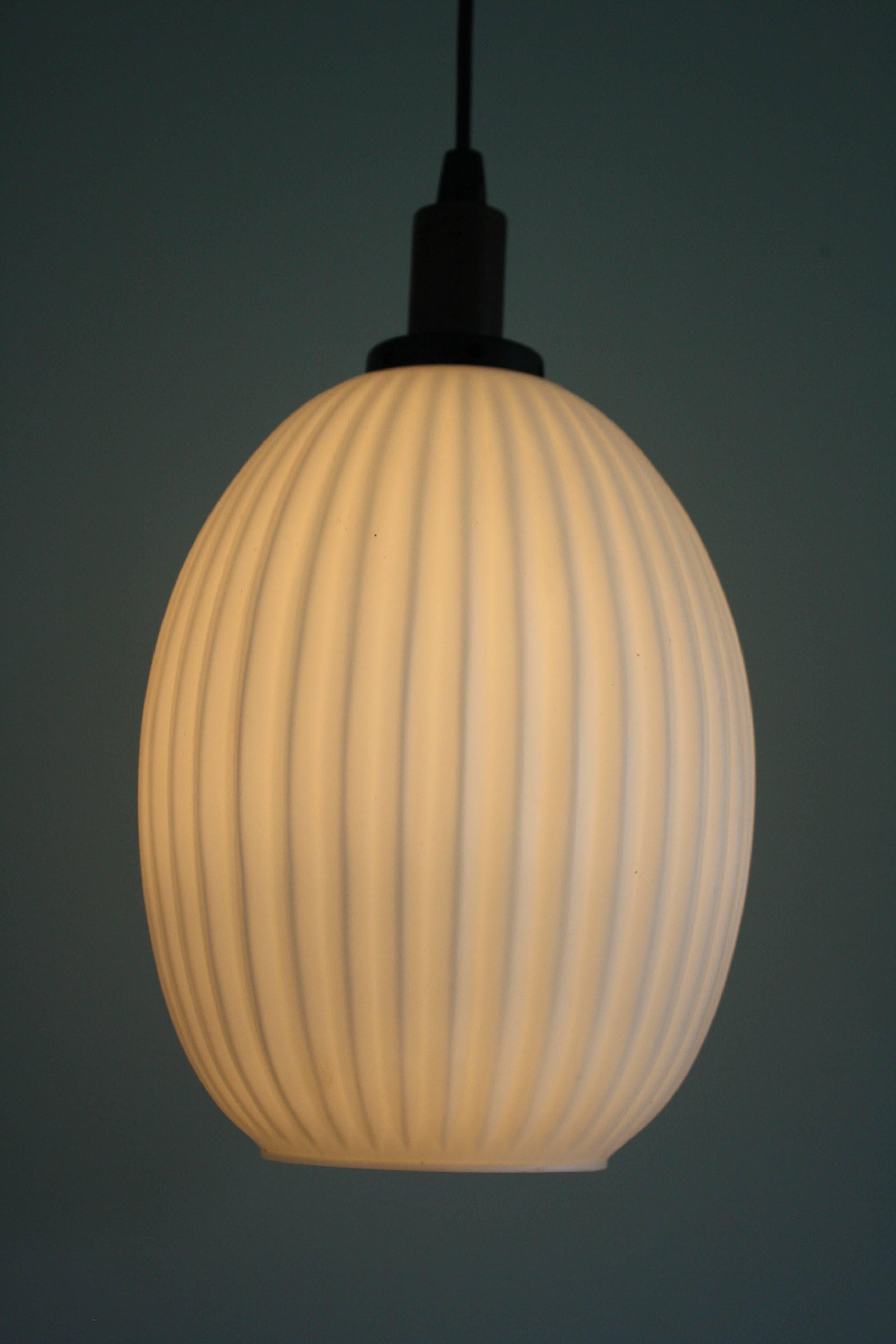 Charming Mid-Century ribbed pendant light.
It features a milk glass shade with a teak shade holder,

1960s, Denmark

Perfect condition. 
Tested and ready to use.

Measures: Height 32 cm/12.60 inch
Diameter shade 20 cm/7.90 inch.