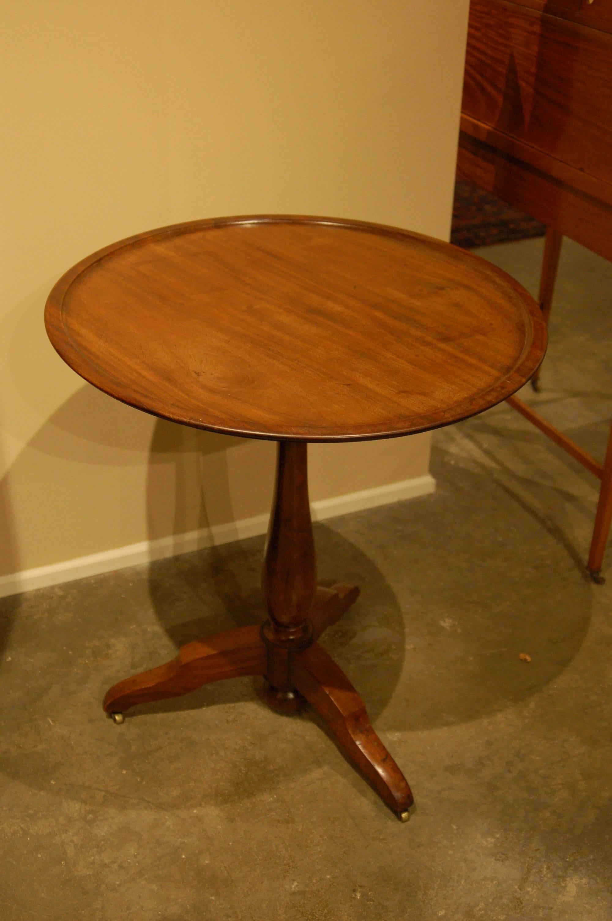 French walnut tilt-top table, carved dish top, original hardware and casters.