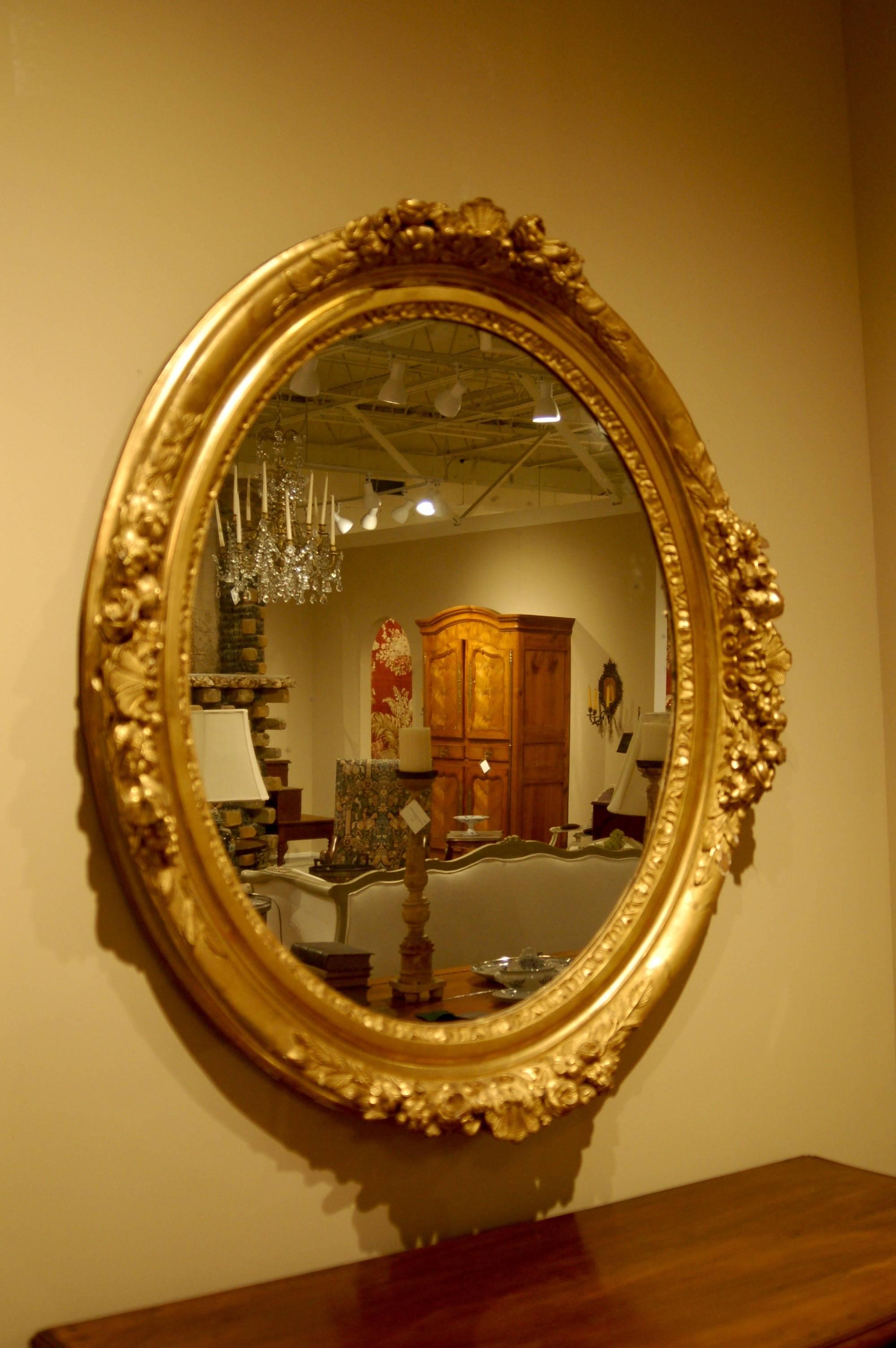 Oval carved and gilt French mirror. Large size in a hard to find shape.