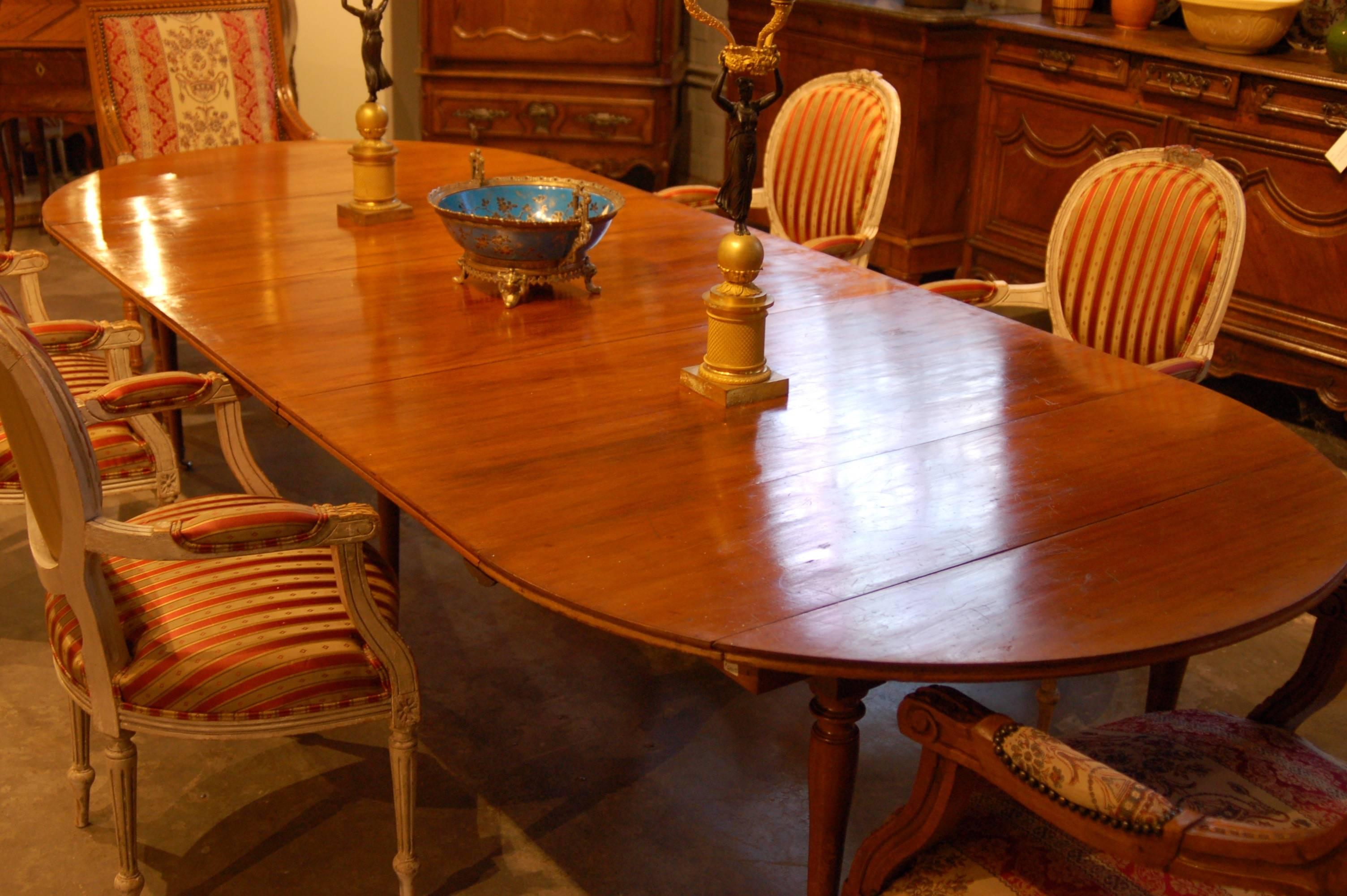 Large extension dining room table with three wide leaves and drop ends.
Closes into a round table 48 inches in diameter. Leaves a later addition but a perfect match and held securely in place with bronze table forks.

 