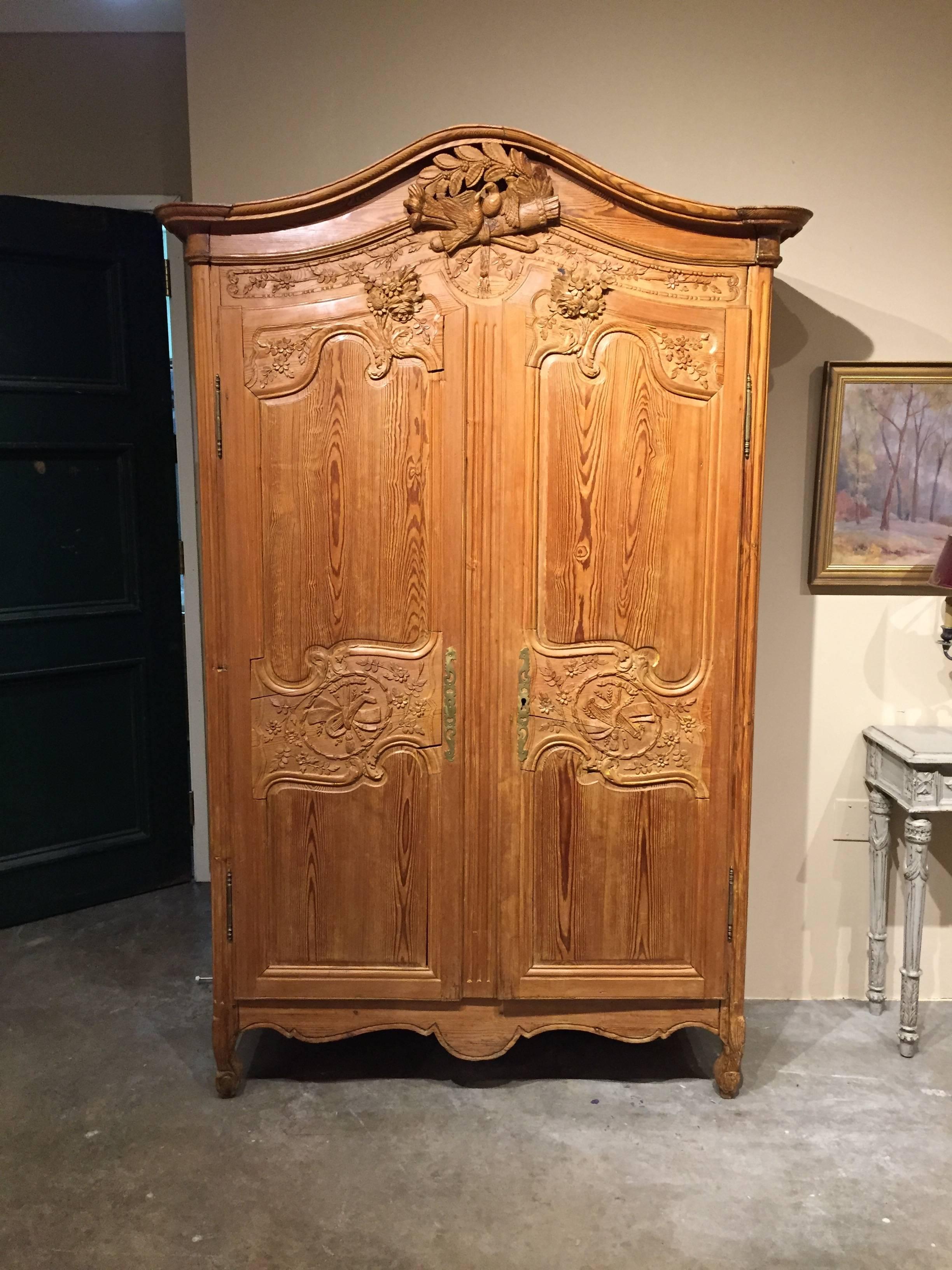 French marriage armoire with excellent detail in carved pine. Retains one shelf and original key.