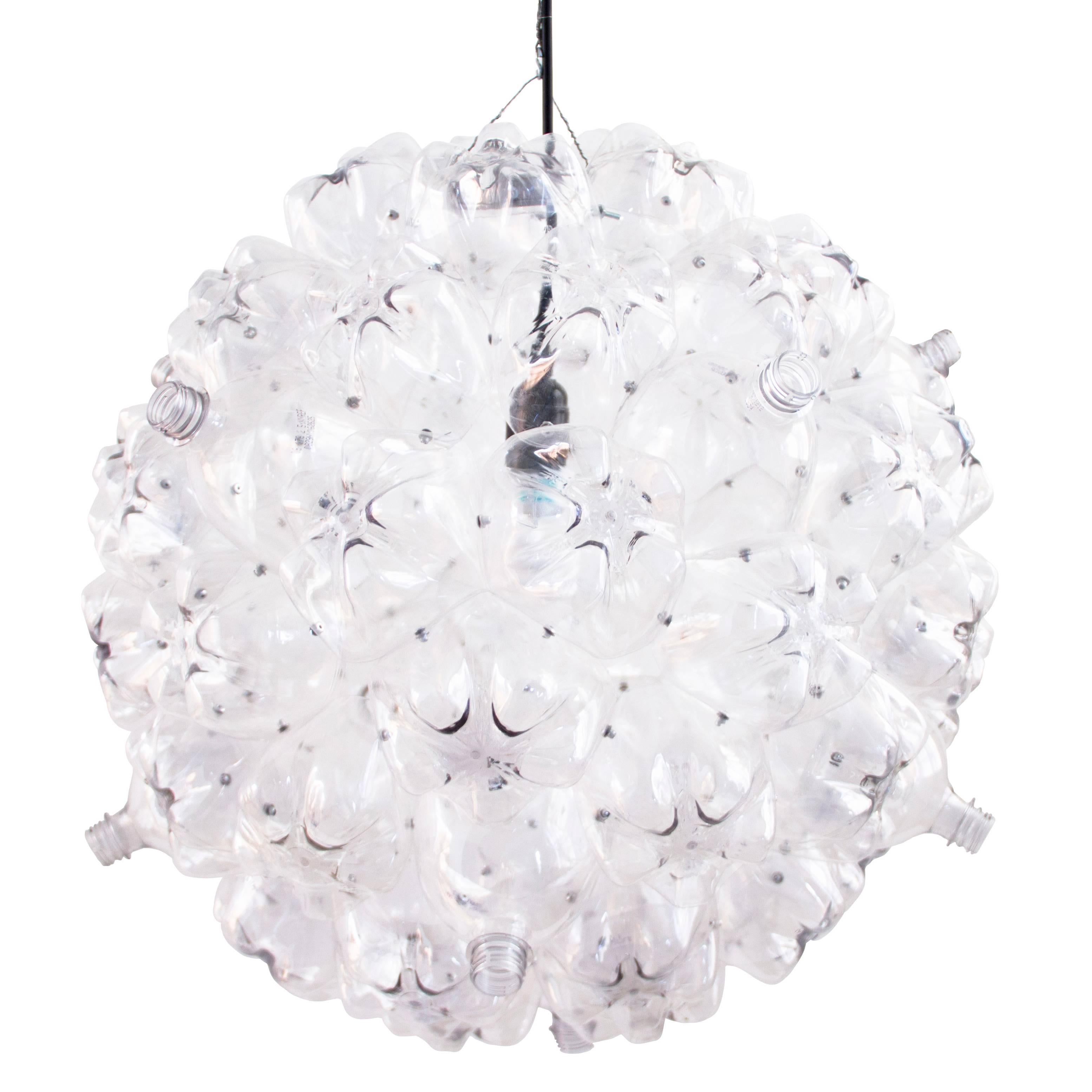 Originally inspired by the cell-like shape of soap bubbles, the bubble chandelier is made from post-consumer PET bottles that have been cleaned, cut, and riveted together. The entirety of the plastic bottles used to create the Bubble Chandelier are