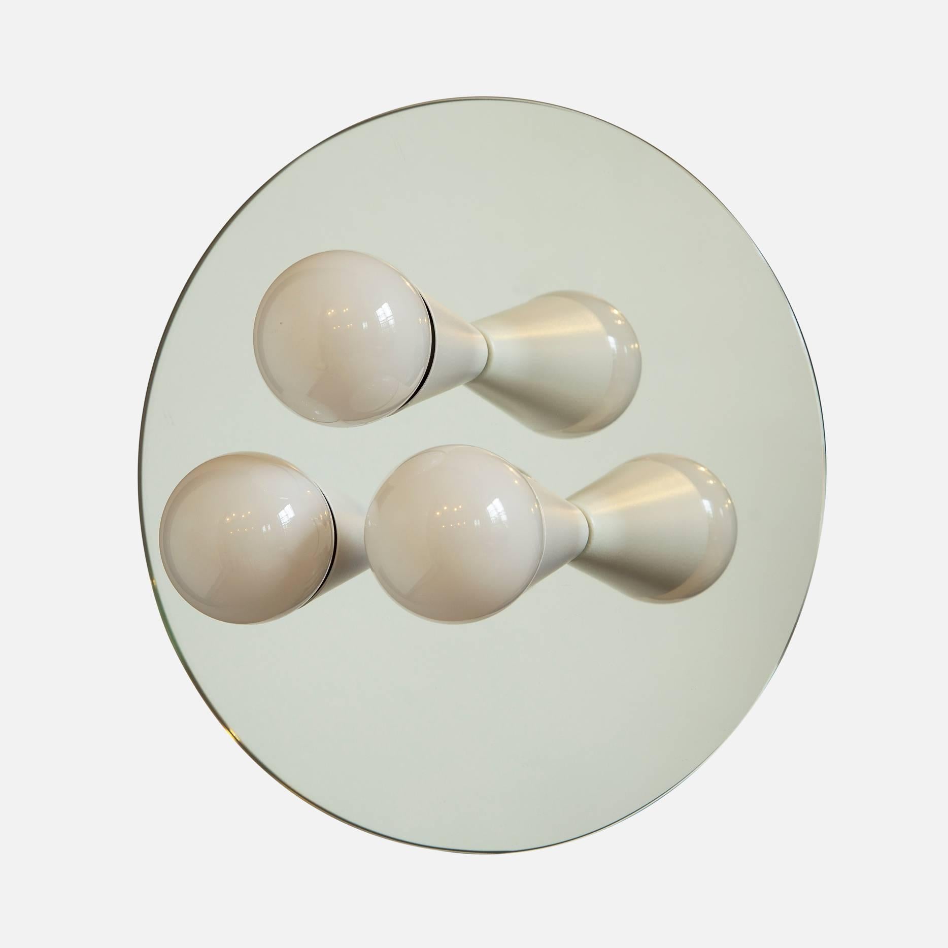 Simple, elegant and playful, the Echo Series is a line of surface-mount fixtures that can be used on a wall or ceiling. White or brass cones mount to mirrored glass to perfectly reflect each bulb, giving the illusion of lights floating in