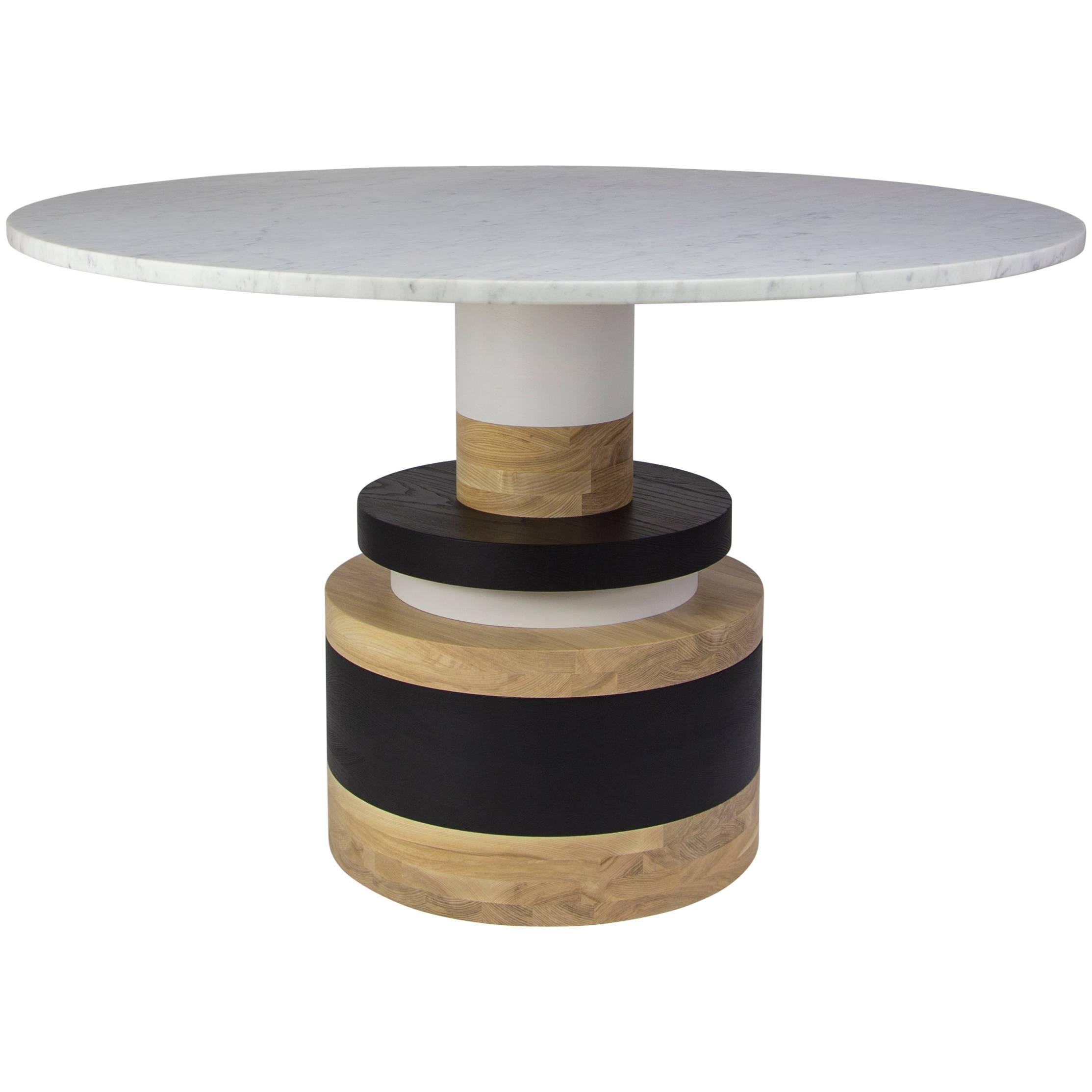 The Sottsass-inspired “Sass Dining Table” is a bold, graphic statement piece. A polished Nero Marquina marble top sits on an Amish-made base composed of painted and stacked wood circles. 

The version as shown is 47