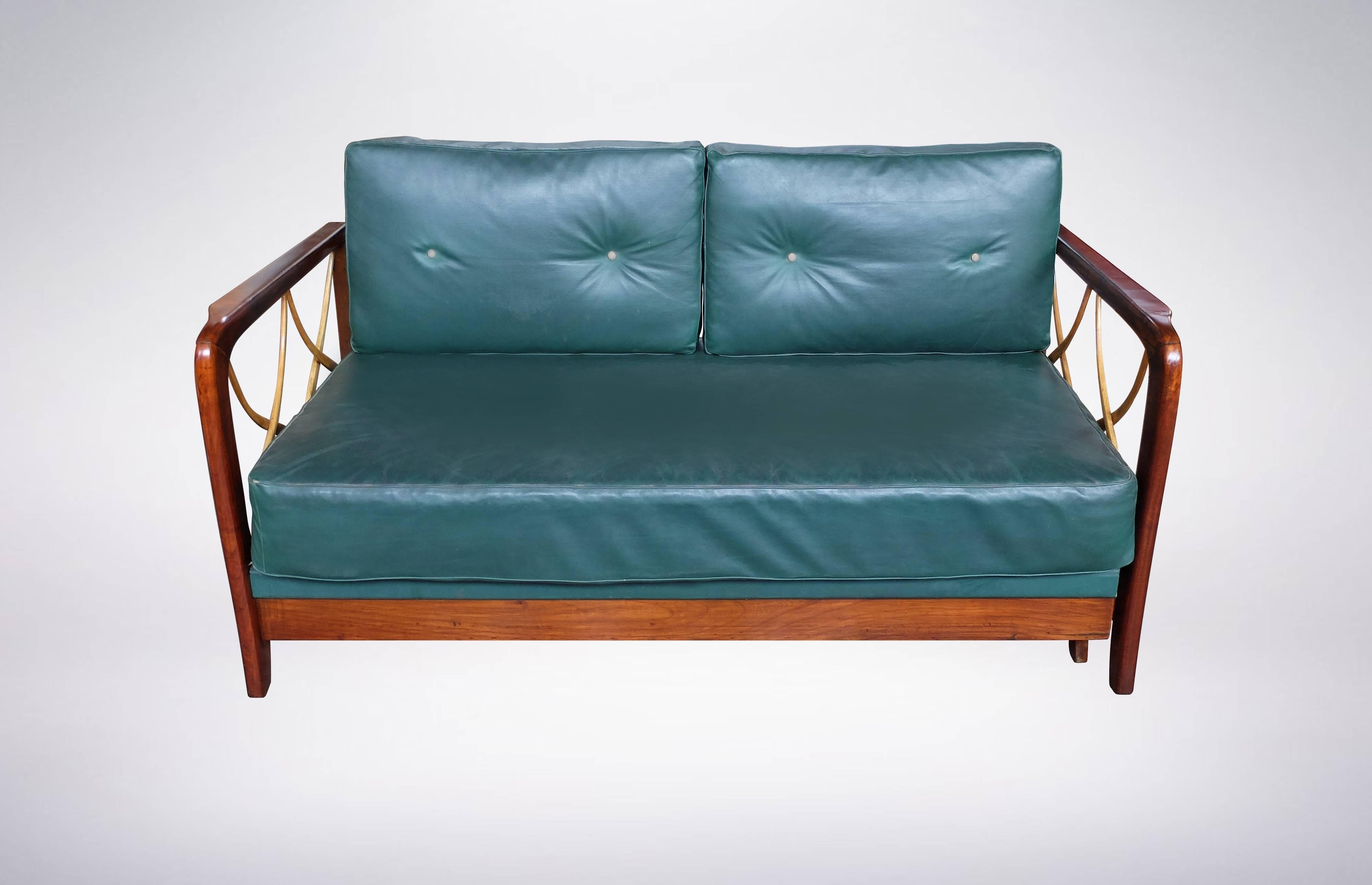 Settee that transforms into daybed maintained with original wooden fittings and green leather upholstery. 
Side collapses that turns it into daybed.
