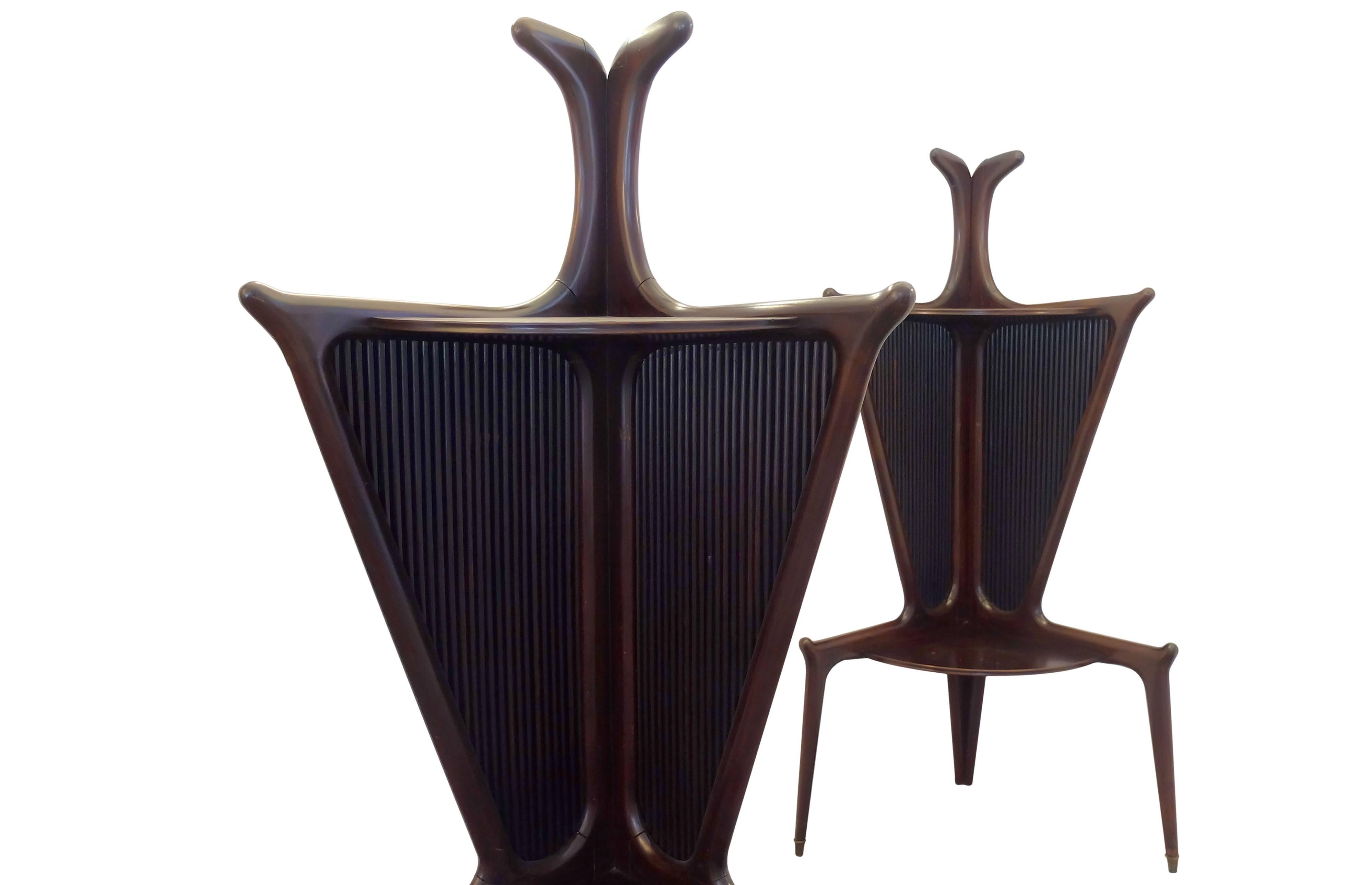 Formed out of lush polished dark rosewood, two stately corner tables of Italian origin from the 1950s, attributed to Pietro Chiesa.

The lean structure opens out into two leaves with a ribbed geometrical pattern carved into the surface, while an
