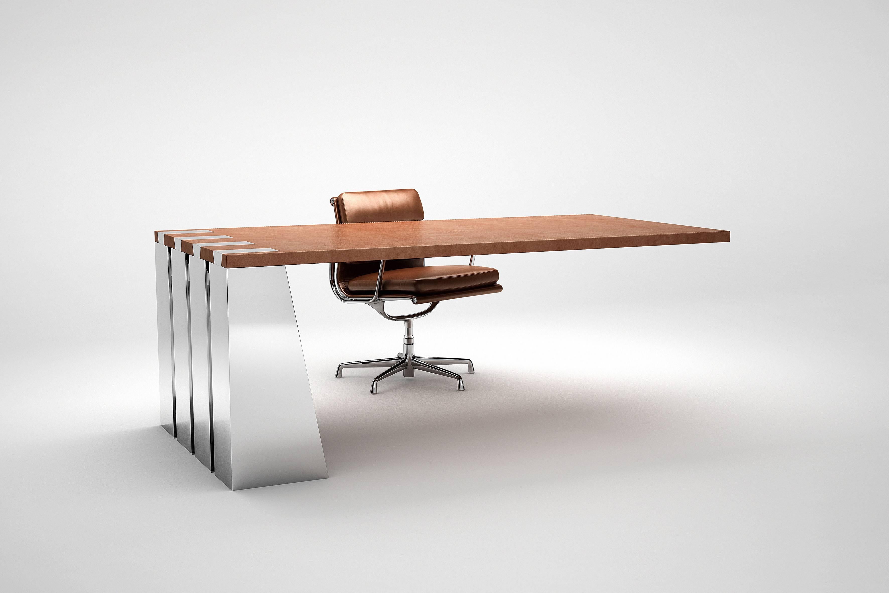 The Zeus desk is both daring and spectacular as the top seems off balance. The refinement of the leather top contrasts with the polished stainless steel legs. The assembling of the top on the four legs is made with elements in a shape of swallows